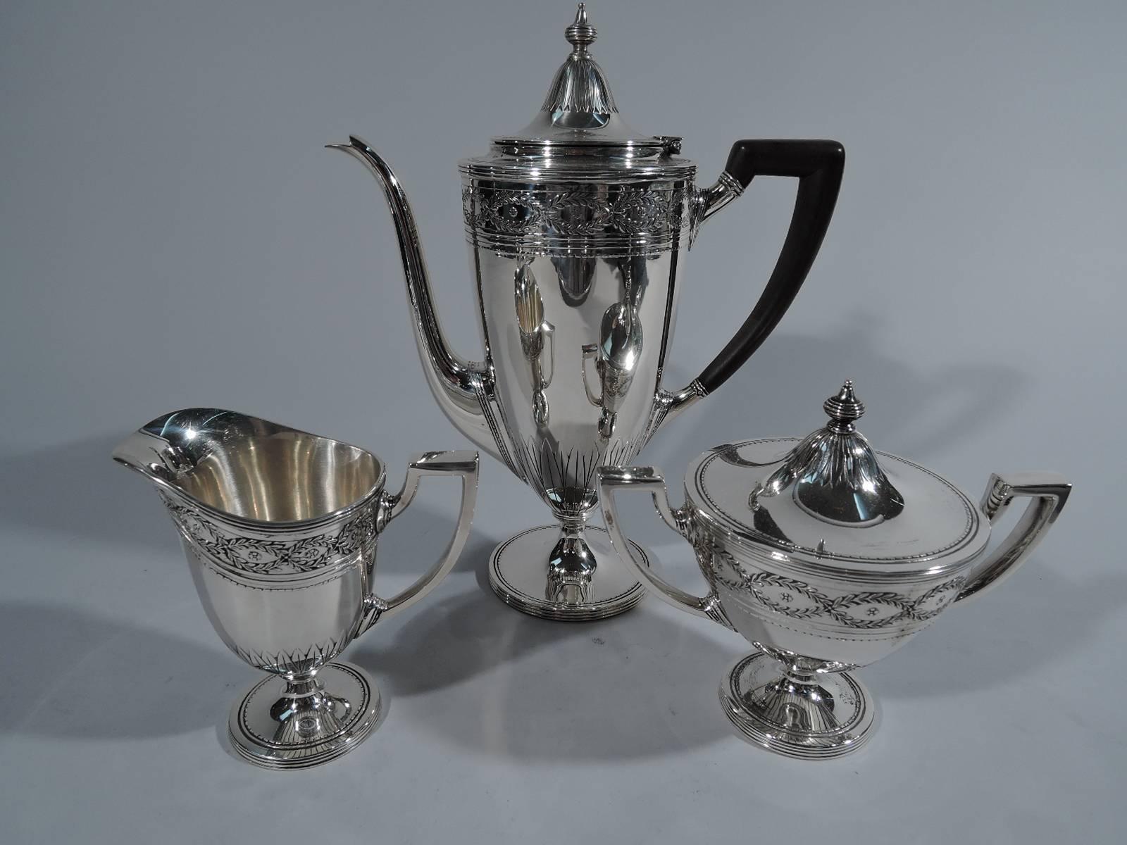 Sterling silver coffee service on tray in Winthrop pattern. Made by Tiffany & Co. in New York. This service comprises coffeepot, creamer, and sugar on tray. 

The Classic Adams-style pattern with laurel wreath borders, dentil, and paterae.