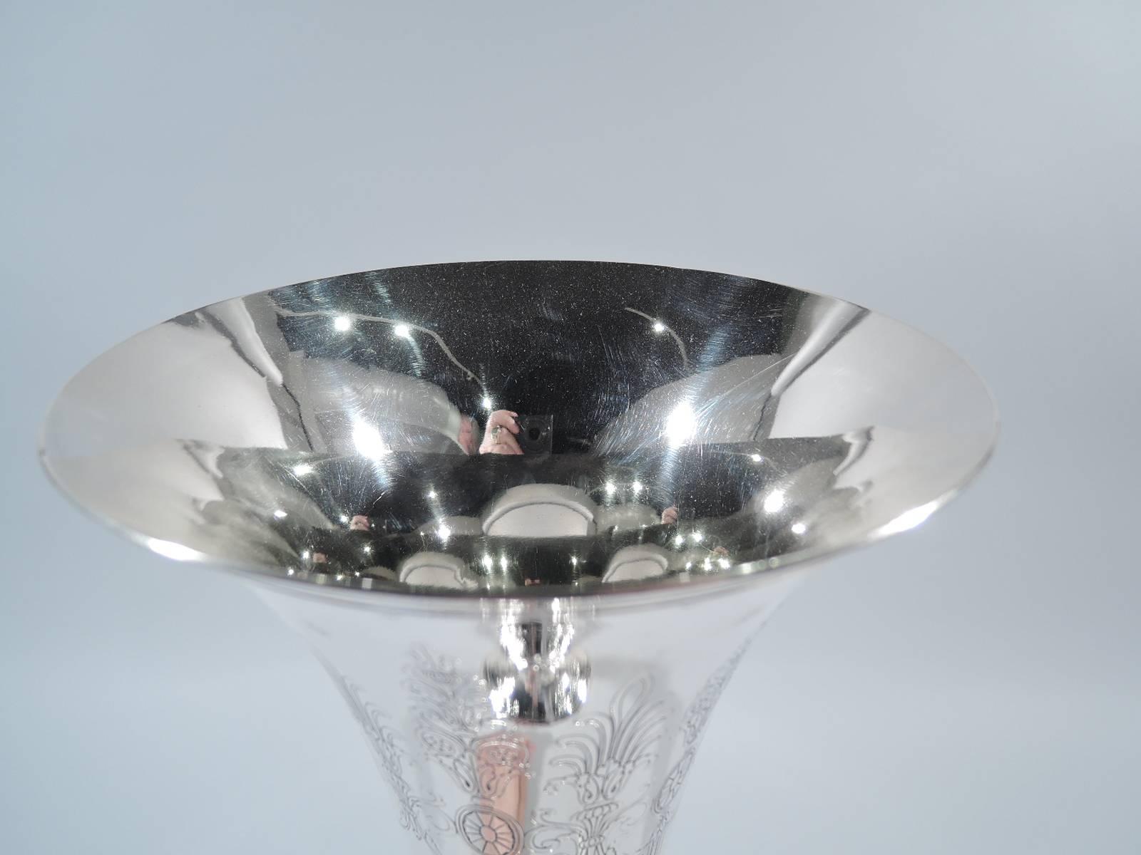 Neoclassical sterling silver trumpet vase. Made by Tiffany & Co. in New York, circa 1913. Tapering sides and stepped raised foot. Acid-etched repeating pattern with swags and paterae and armorial shield frames (all vacant). Stylized leaves at base.