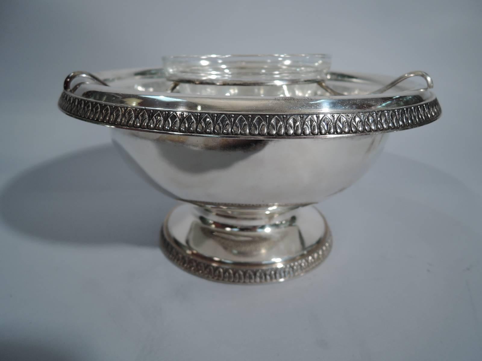 Classical sterling silver caviar bowl. Made by Buccellati in Italy. Curved bowl with turned-down rim, short stem, and raised foot. Rims have applied leaf-and-dart ornament. With clear glass liner, sterling silver frame, and clear glass bowl. A