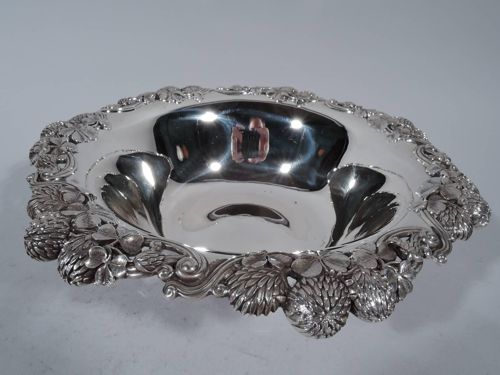Sterling silver bowl in famed clover pattern. Made by Tiffany & Co. in New York. Tapering sides and turned-down rim with bunched blossoms. A beautiful piece in this gilded age high-low pattern that combines wild flowers and precious metal. Hallmark