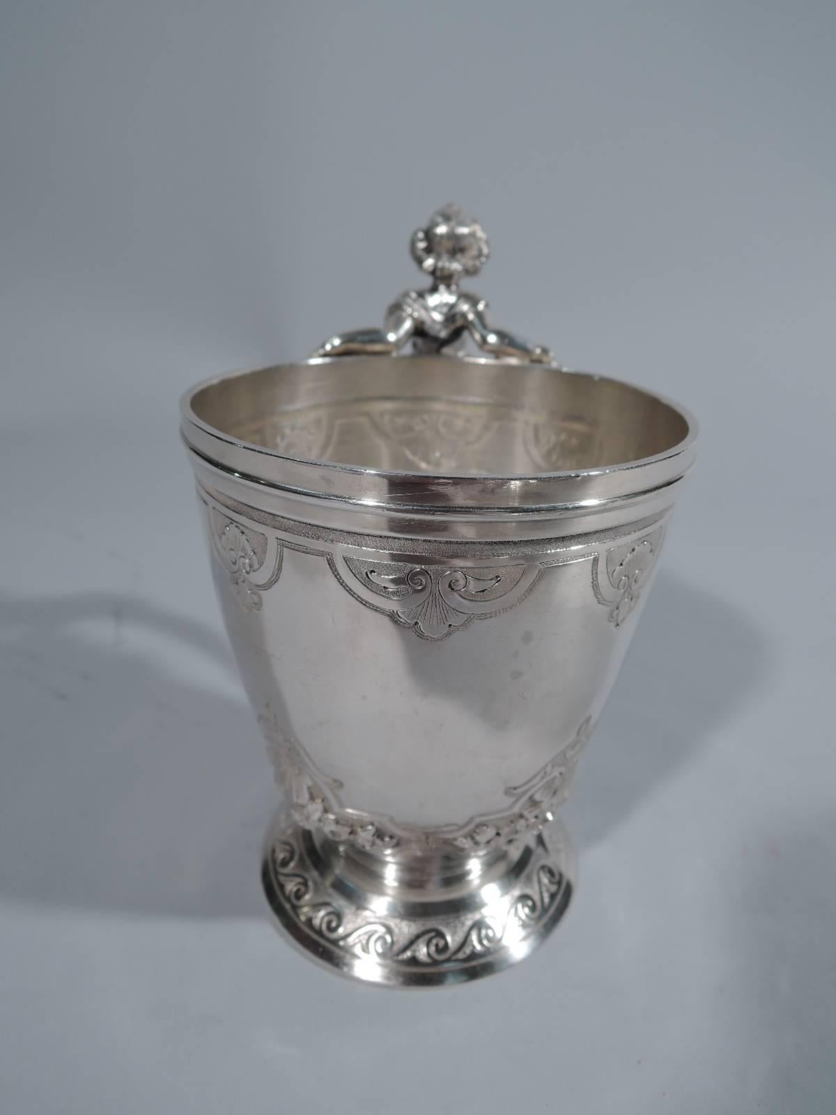 Coin silver baby cup. Made by Gorham in Providence, circa 1860. Curved and tapering sides on raised foot. Strapwork inset with flowers and rinceaux. Cast caryatid handle in form of classical female with grape bunch mounts. Hallmark includes no. 503.