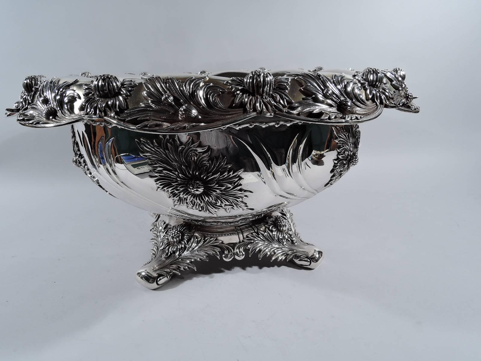 Very desirable sterling silver punchbowl and ladle in Chrysanthemum pattern. Made by Tiffany & Co. in New York. The bowl has curved sides and turned-down scalloped rim. Raised base terminating in four volute scrolls. Chrysanthemums applied to rim,