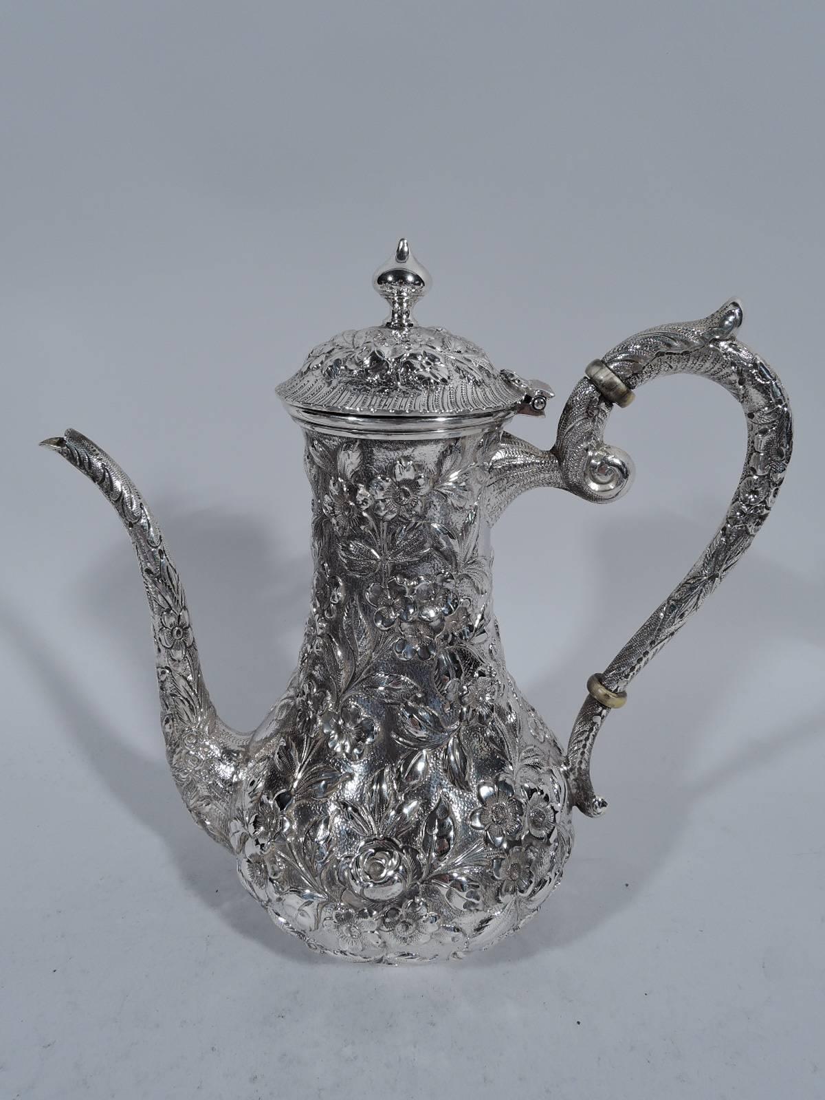 Sterling silver coffee set. Made by Heer-Schofield in Baltimore, circa 1910. This set comprises coffeepot, creamer, and sugar. Each: baluster body with molded rim and raised foot. Allover floral repousse on stippled ground. Coffeepot has capped