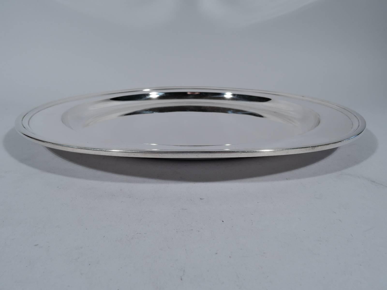 Deep and heavy sterling silver tray. Made by Tiffany & Co. in New York, circa 1923. Circular with deep well and molded rim. Hallmark includes pattern no. 20188 (first produced in 1923) and director's letter m (1907-47). Weight: 30.8 troy ounces.