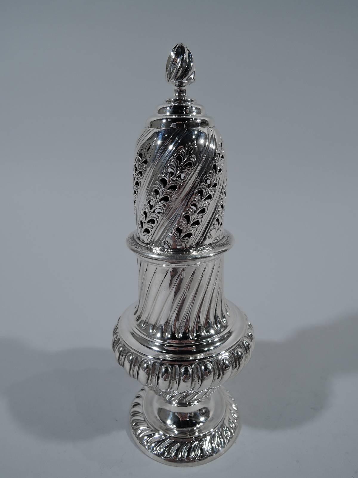 Victorian sterling silver sugar caster. Made by Fenton Bros. in Sheffield in 1889. Baluster body on raised foot. Twisted gadrooning. Cover has twisted gadrooning alternating with pierced leaves. Strapwork cartouche has engraved armorial. A fine