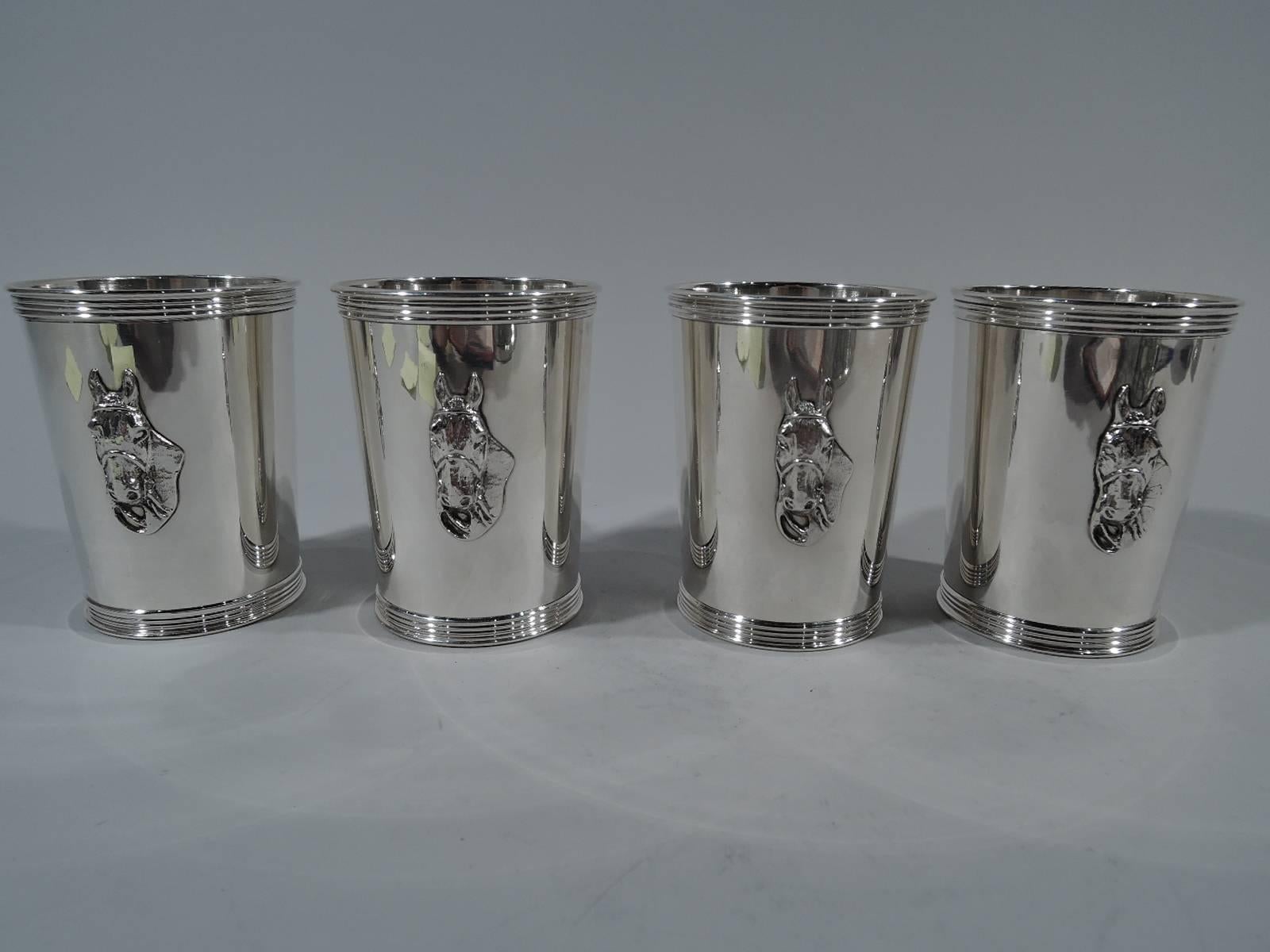 Set of four sterling silver mint julep cups. Retailed by Trees in Lexington, Kentucky. Each: straight and tapering sides, reeded rims, and applied horse head. A realistic equine portrait with erect ears, wide nostrils, and direct gaze. A great Derby