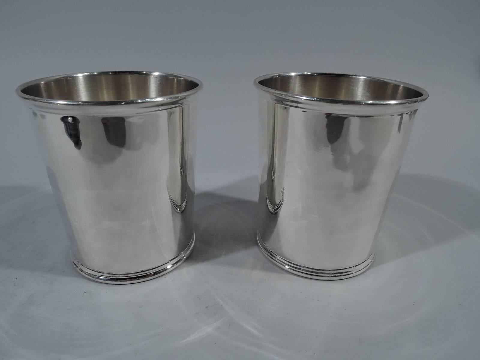 Pair of American sterling silver mint julep cups. Each: Traditional form with straight and tapering sides and molded rims. Hallmarked “Sterling”. Good condition. Total weight: 9.2 troy ounces.
