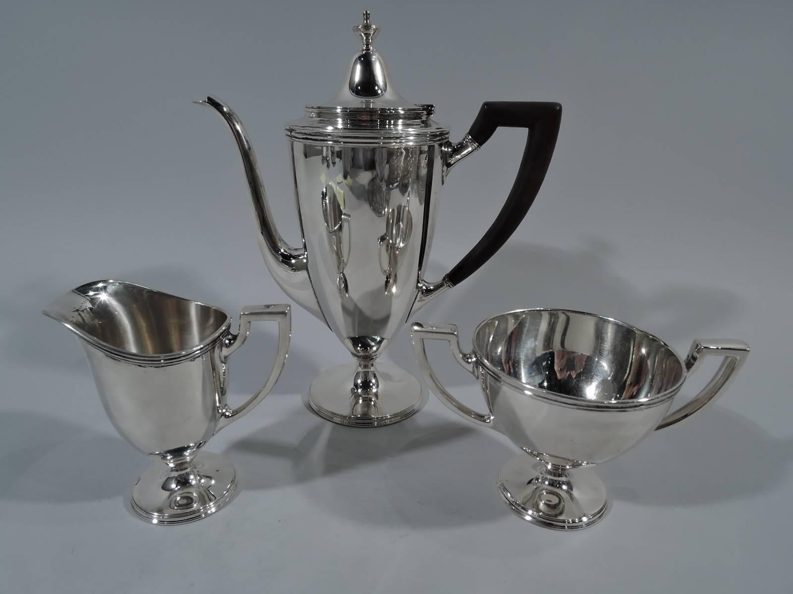 Traditional sterling silver coffee service. Made by Tiffany & Co. in New York, circa 1928. This service comprises coffeepot, creamer and sugar.

Each: Georgian form with stepped foot, reeded rim, and scroll-bracket handle. Coffeepot has hinged