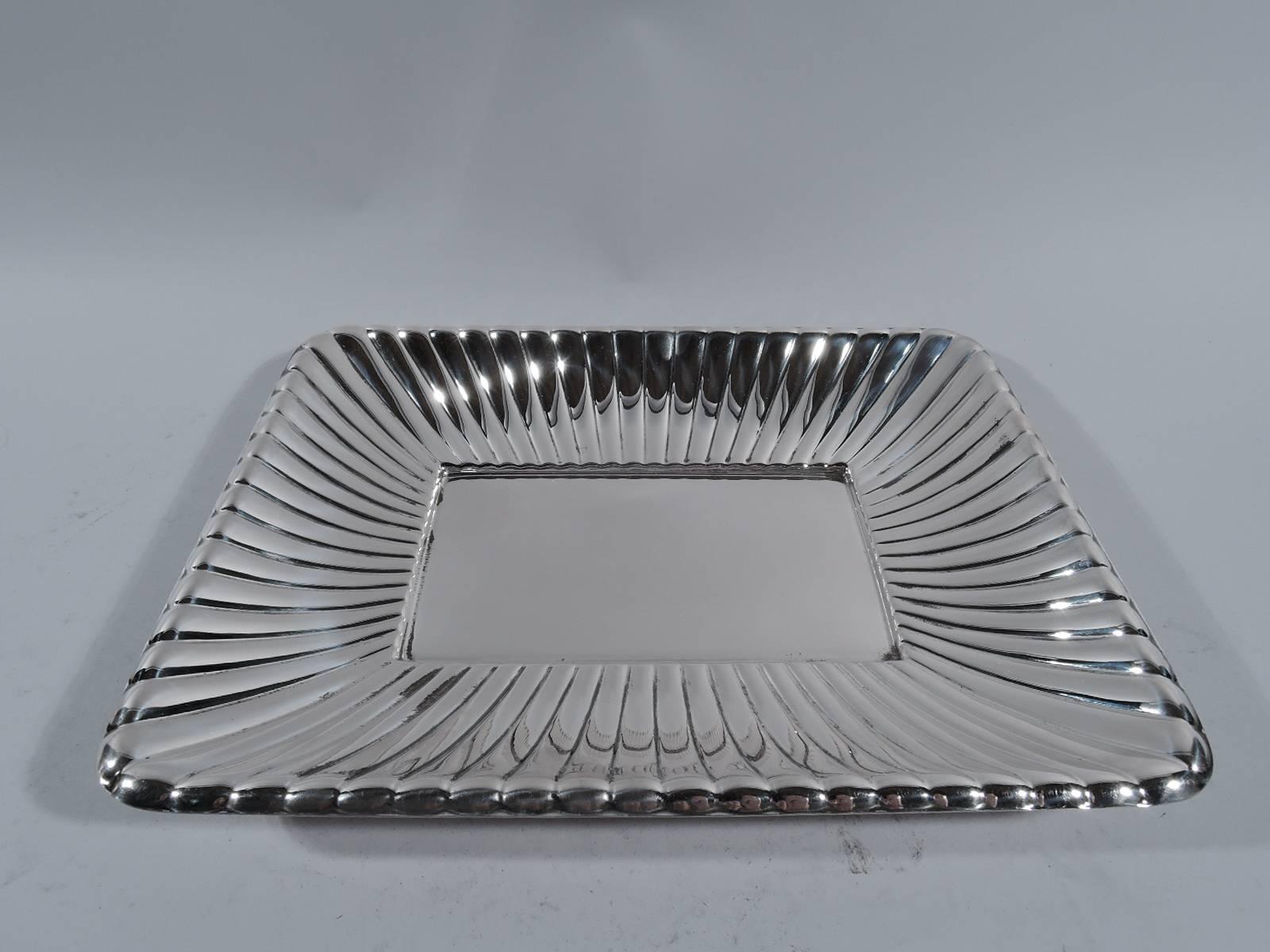 Unusual and Modern sterling silver bowl. Made by Cartier in New York. Shallow and rectangular with plain well surrounded by radiating gadrooning. Hallmark includes no. X302. Weight: 15 troy ounces.