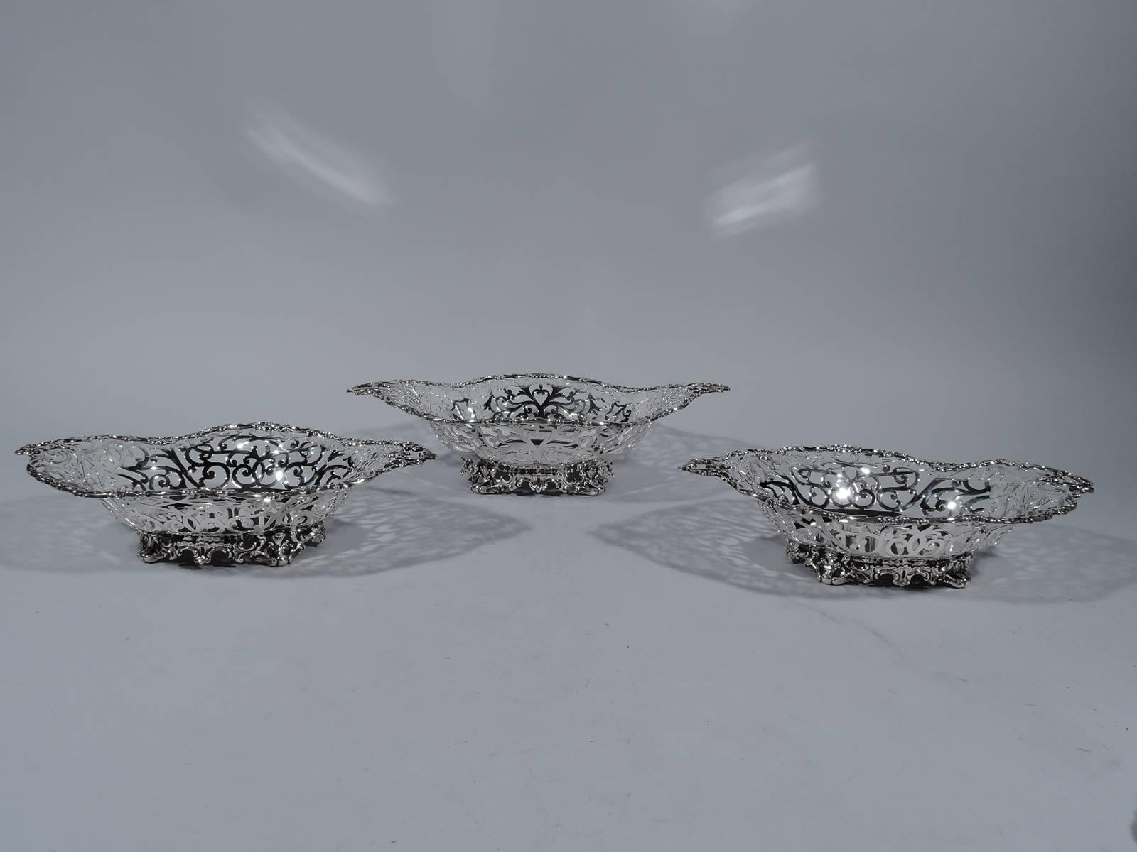 Sterling silver three-basket centrepiece garniture. Made by Howard in New York in 1895. Each: Well is solid and elongated quatrefoil and sides have pierced scrollwork. Rim has applied scrolls. Foot comprises pierced scrolls. Hallmark includes year.