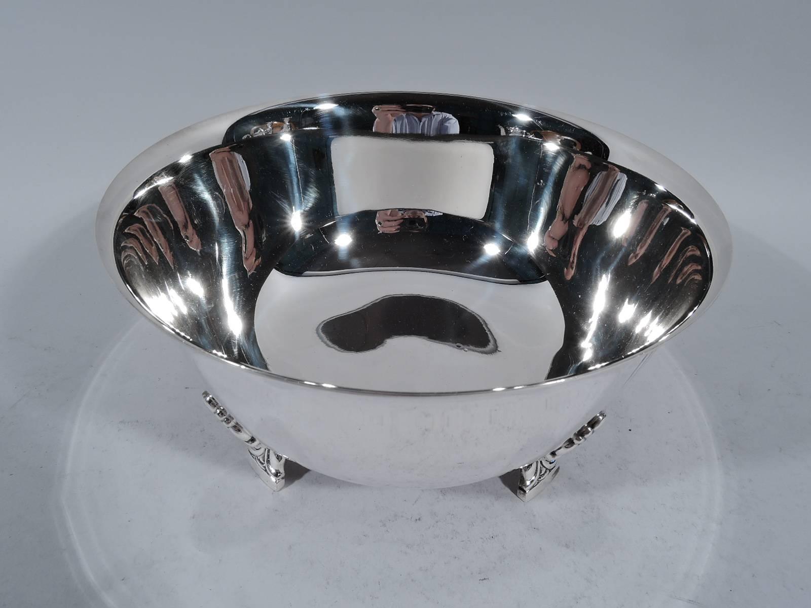 Sterling silver bowl in Palmette pattern. Made by Tiffany & Co. in New York. Curved sides and flared rim. Rests on 4 stylized floral supports. Each support radiates three incised and tapering lines. An early piece in this pattern, which was first