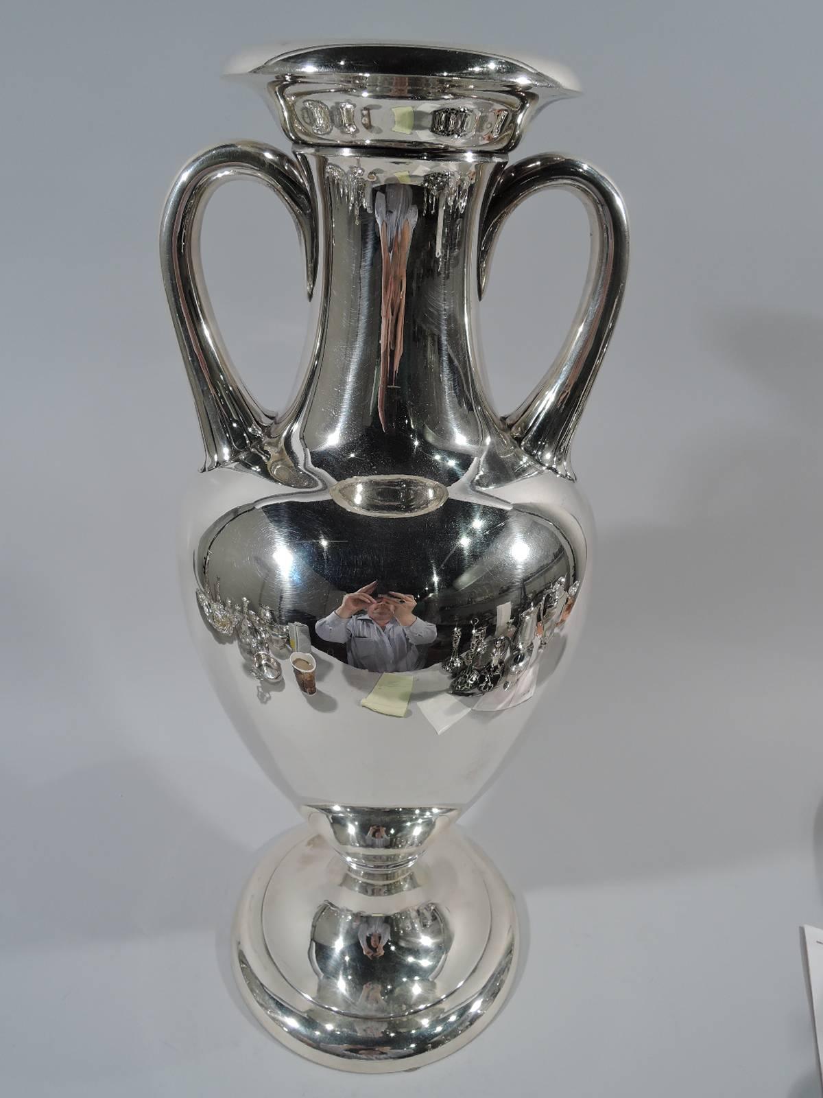 Tall and heavy sterling silver trophy cup. Made by Tiffany & Co. in New York, ca 1905. Traditional Amphora vase. Handles have scalloped petal mounts. Bottom has reeded band. Substantial with lots of room for engraving. Hallmark includes pattern