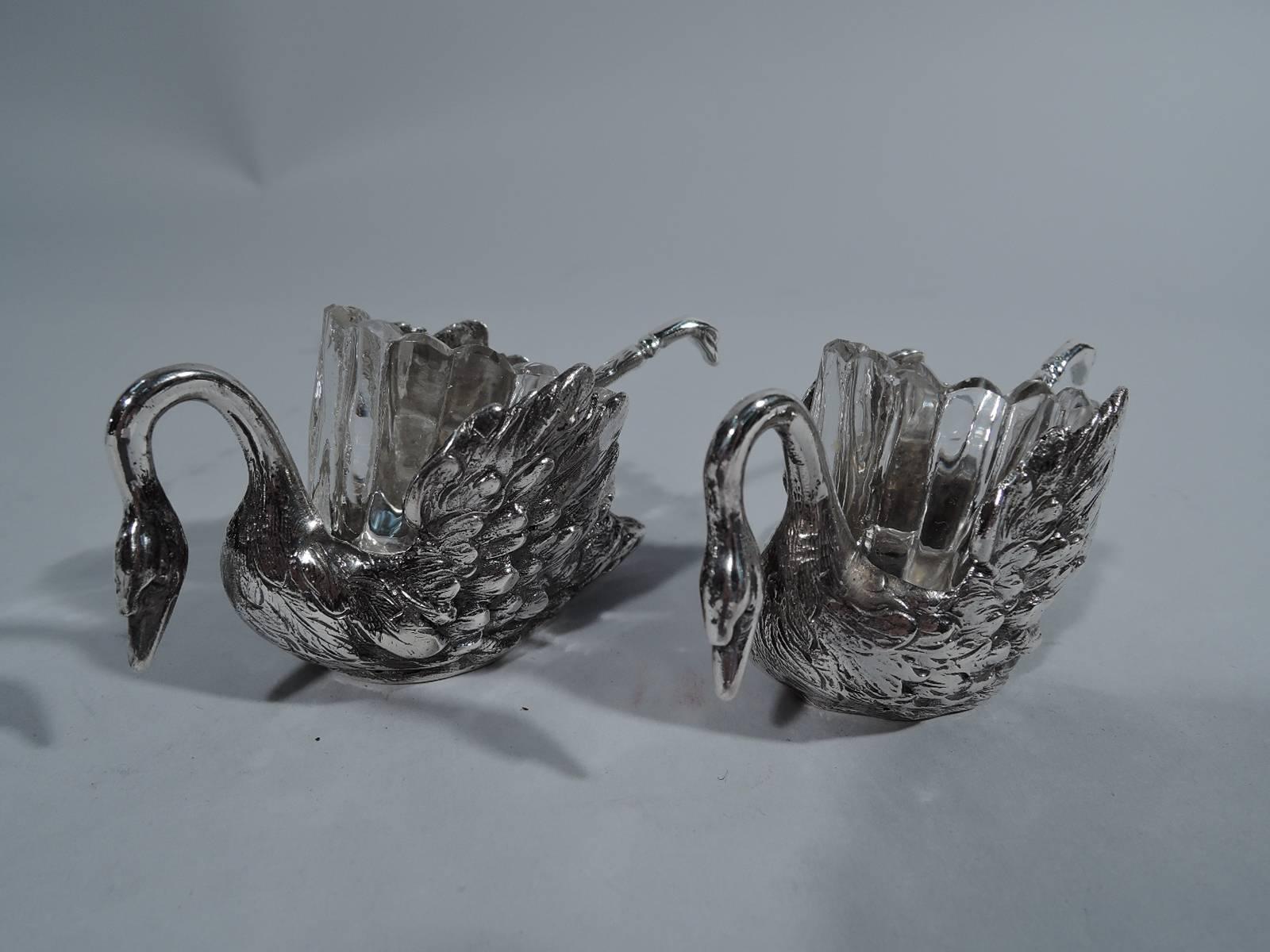 Set of four German 800 silver swan-form open salts with glass liners, circa 1900. Each bird has big downy wings and slender neck terminating in pointed bill. Liner is clear glass with fluting and scalloping. German hallmark. Dimensions: H 1 3/4 x W