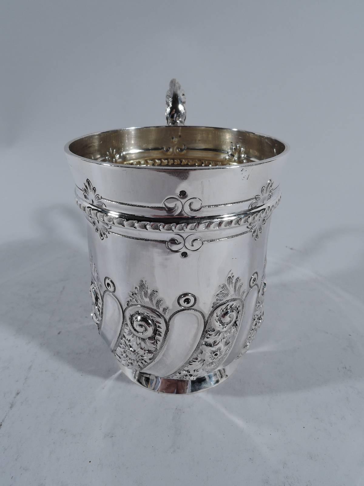 Victorian sterling silver baby cup. Made by Martin, Hall in Sheffield in 1895. Curved bottom, spread foot, and leaf-capped scroll handle. Near rim ornamental band. At bottom flutes alternating with ornamented gadroons. Sweet and pretty. Hallmarked