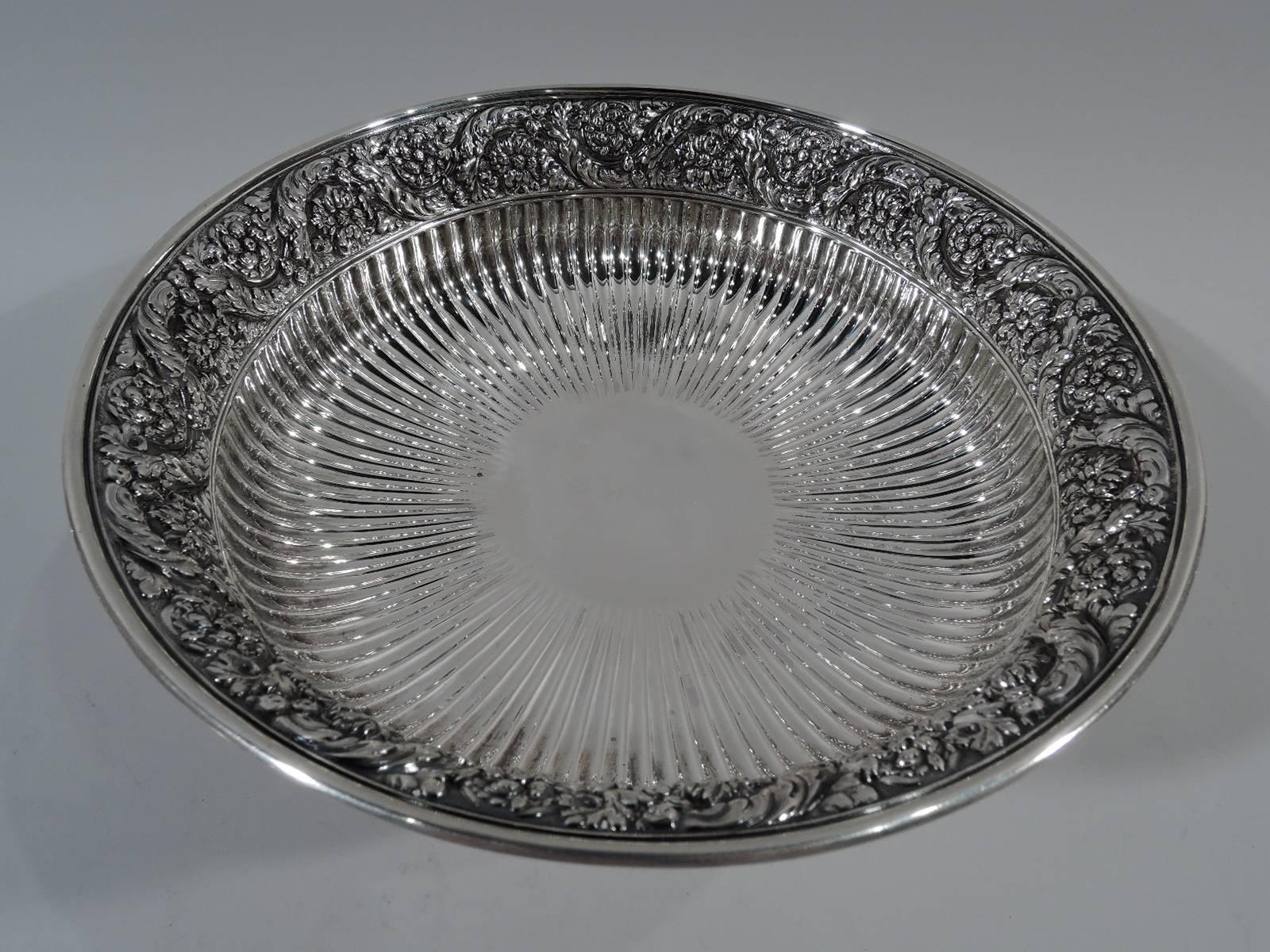 Sterling silver compote. Made by Tiffany & Co. in New York, circa 1882. Bowl has flat well, tapering sides, and flared rim. Short support with raised foot. Bowl interior has central circular frame (vacant) radiating flutes. Rim interior and foot