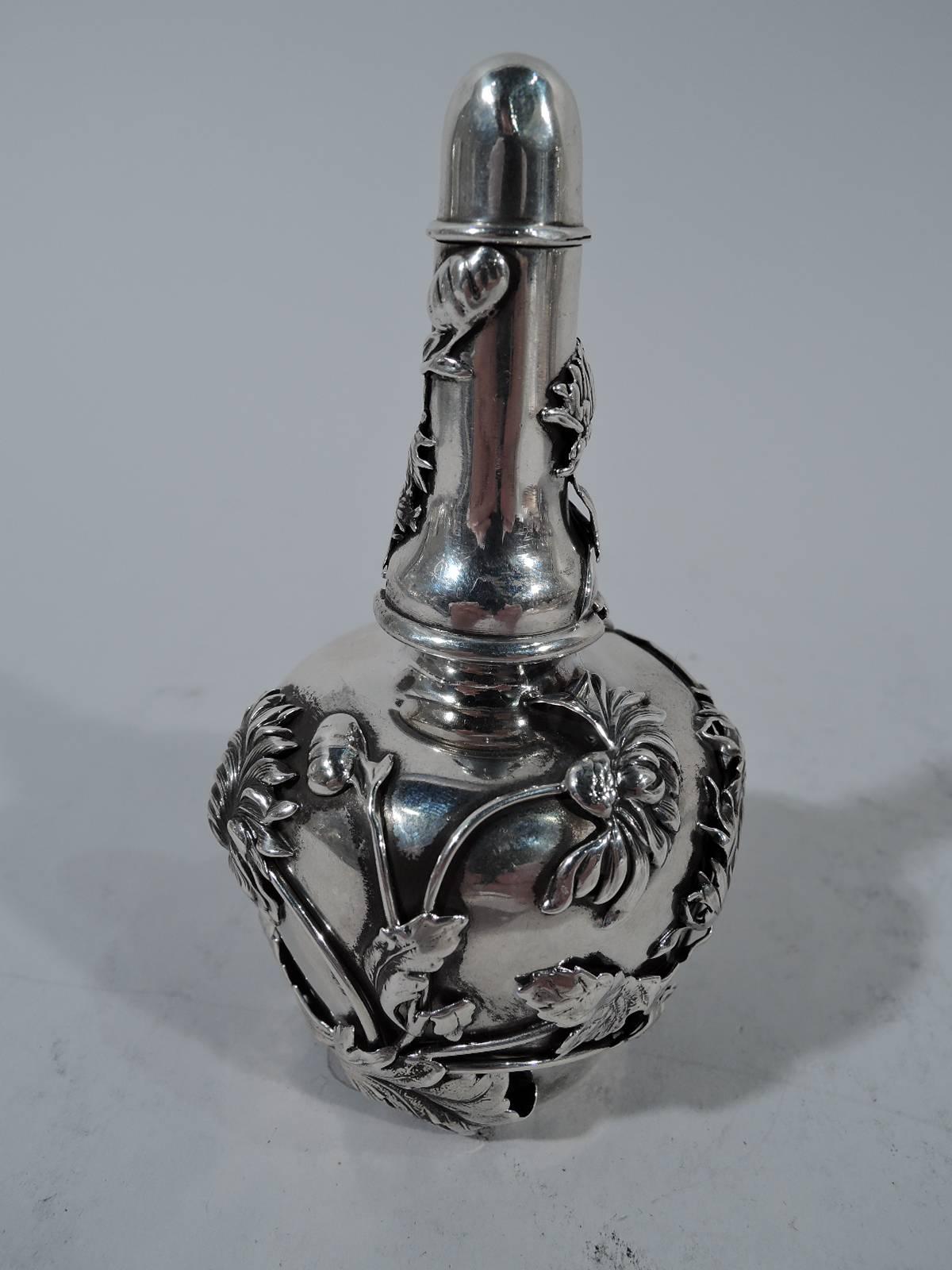 Aesthetic sterling silver scent bottle. Made by Shiebler in New York, circa 1880. Squat tapering bowl with short neck. Cover tall and conical with lift-up cap for daubing scent. Applied wrap-around chrysanthemums. Advanced design and ornament.