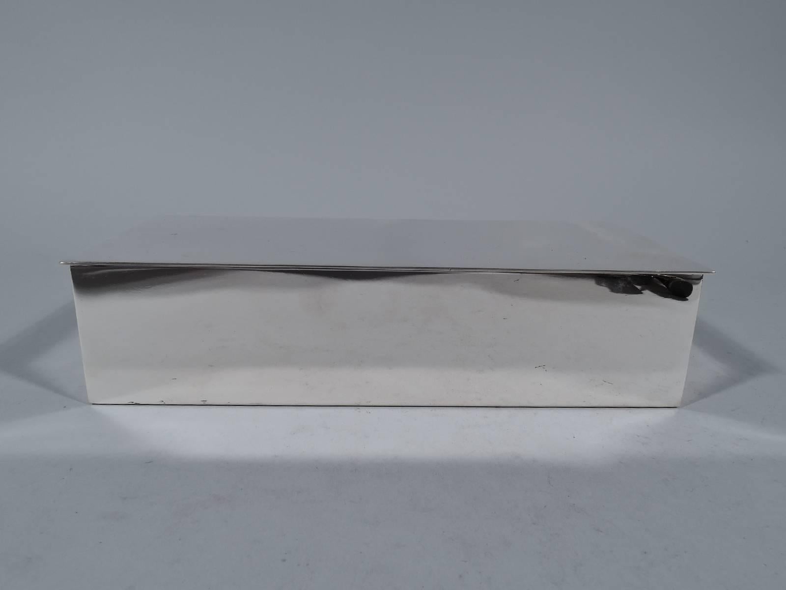 Sterling silver desk box. Made by Tiffany & Co. in New York. Rectangular with straight sides. Cover flat and hinged with discreet overhang. Box interior cedar-lined and partitioned. Hallmark includes postwar pattern no. 23328. Gross weight: 19.6