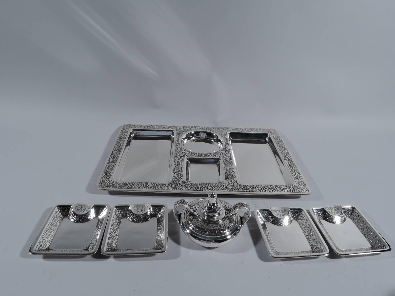 Edwardian sterling silver smoking set. Made by Tiffany & Co. in New York, circa 1916. This set comprises one tray, four ashtrays, and one lighter.

Tray has 4 plain wells: Two rectangles for cigars and cigarettes, 1 square for matches, and 1