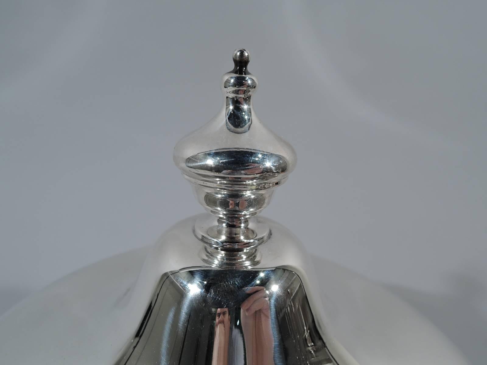 Classical sterling silver trophy cup. Made by Gorham in Providence in 1896. Urn bowl with molded band, leaf-capped double-scroll side handles, and raised foot. Dome cover with vase finial. Gadrooned rims. Hallmark includes date symbol and no.