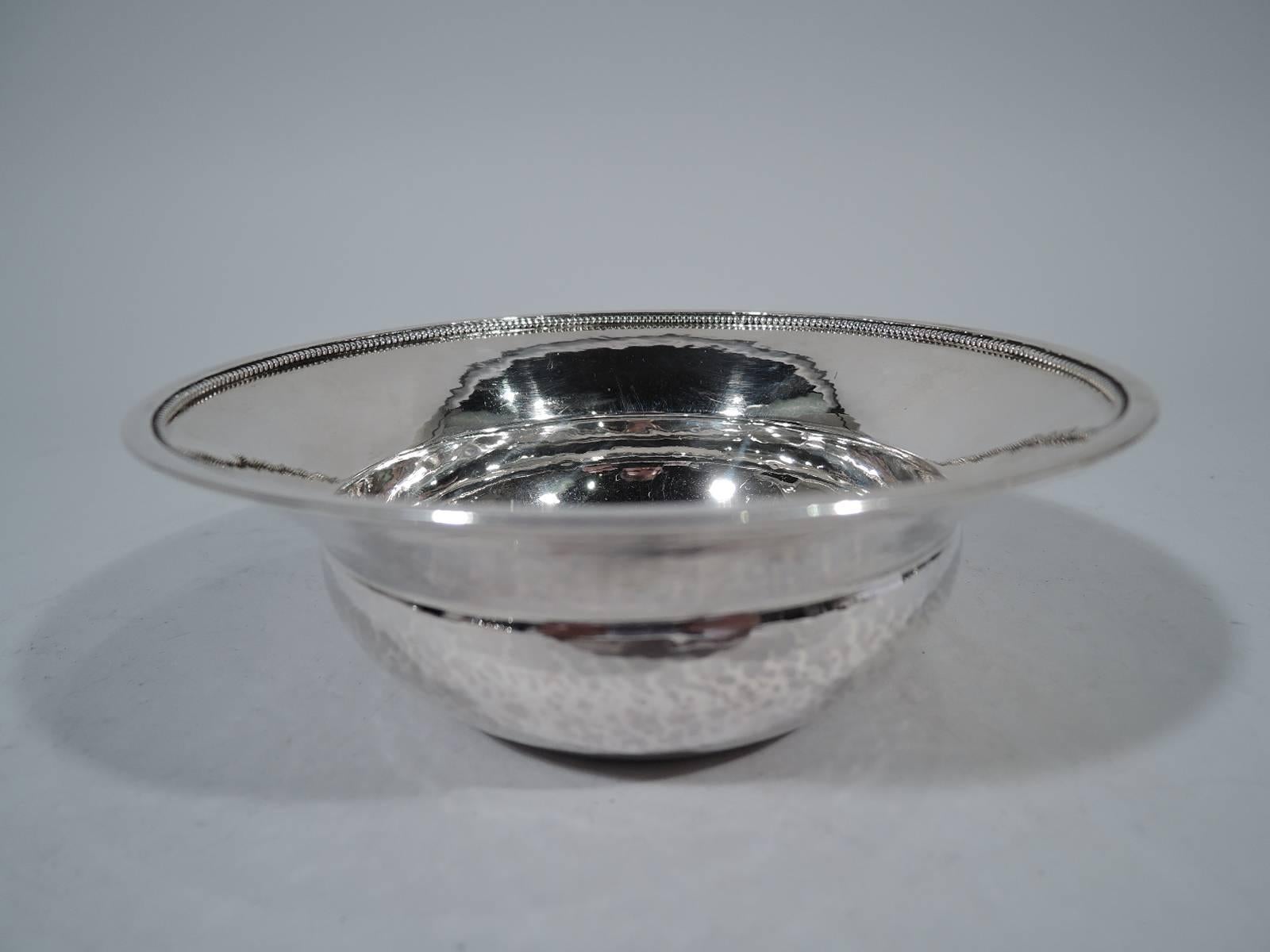 Sterling silver bowl. Made by Georg Jensen in Copenhagen. Bellied bowl and straight, tapering, and wide rim with applied beading. Visible hand hammering. An idiosyncratic design from the prewar years. Hallmark (circa 1933-1944) with no. 379. Weight: