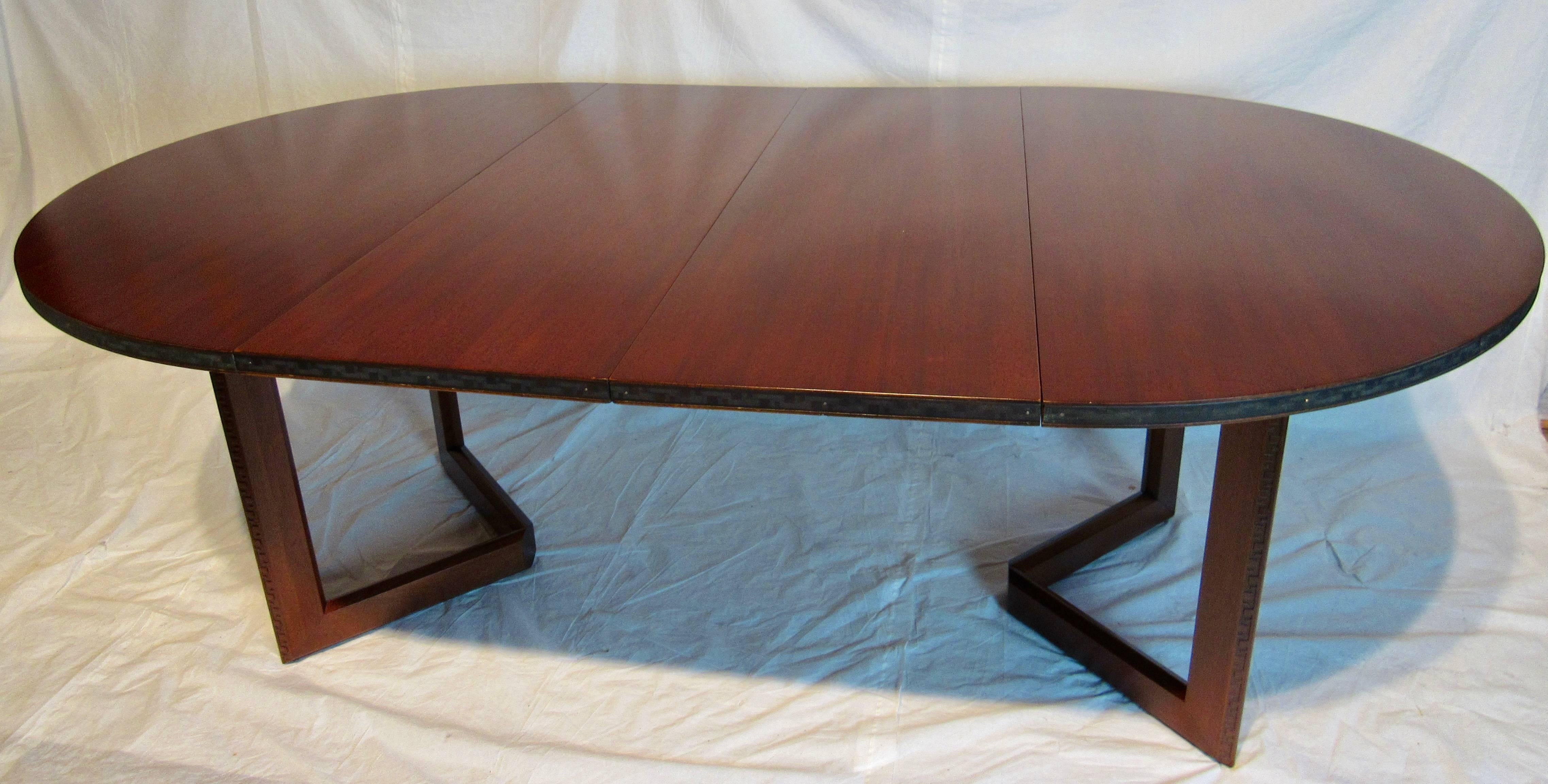 A mahogany dining table designed by Frank Lloyd Wright as part of his Taliesin line of furniture manufactured by Heritage Henredon between, 1955-1956. A very versatile table with (two) 18 inch leaves thus extending the 48 inch round table to 84