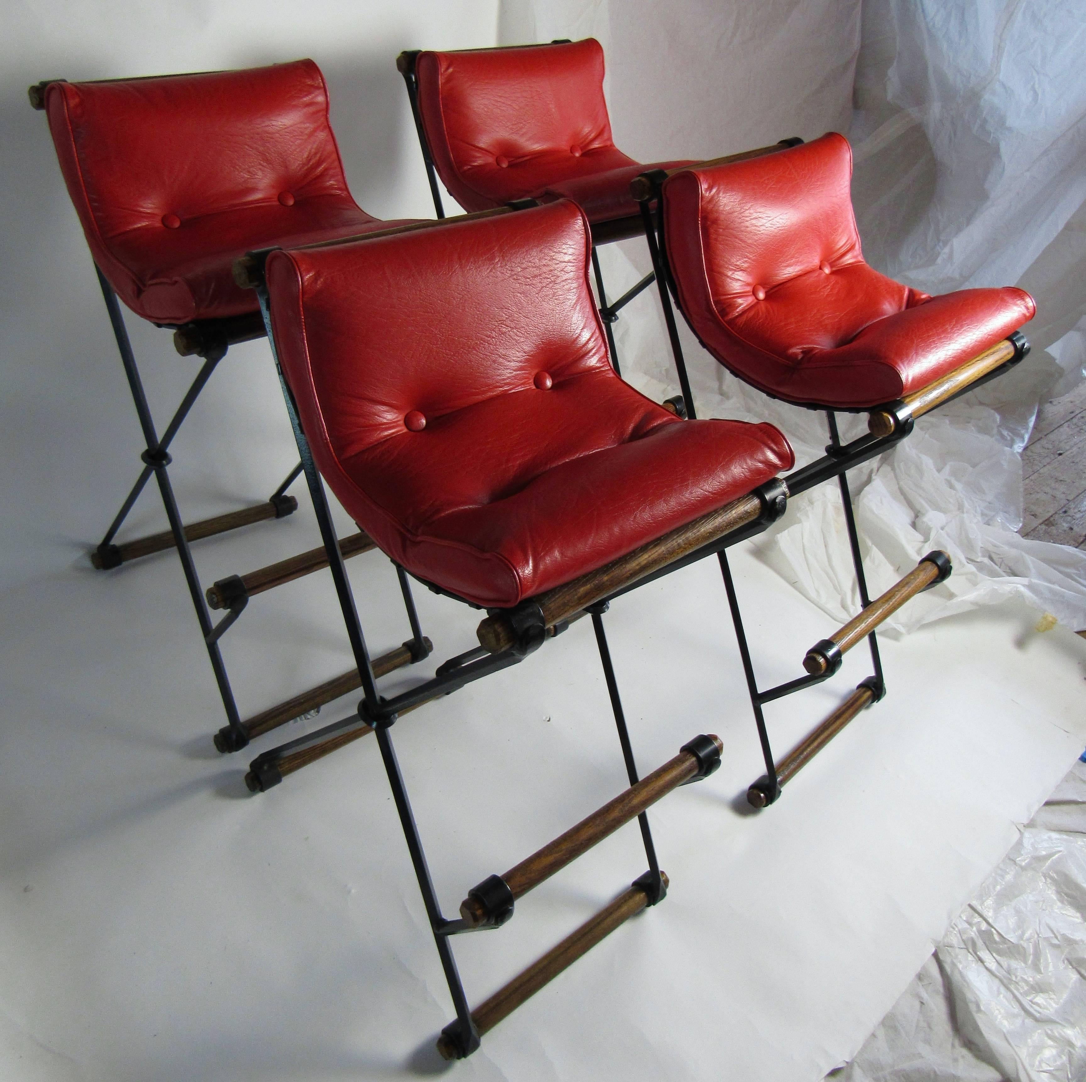 Four Cleo Baldon wrought iron and oak bar stools manufactured by her company Terra in the 1960s. 
Dean Martin a non-drinker had a suite of similar stools at his home in Palm Springs and requested Cleo to redesign the stool with a higher back so his