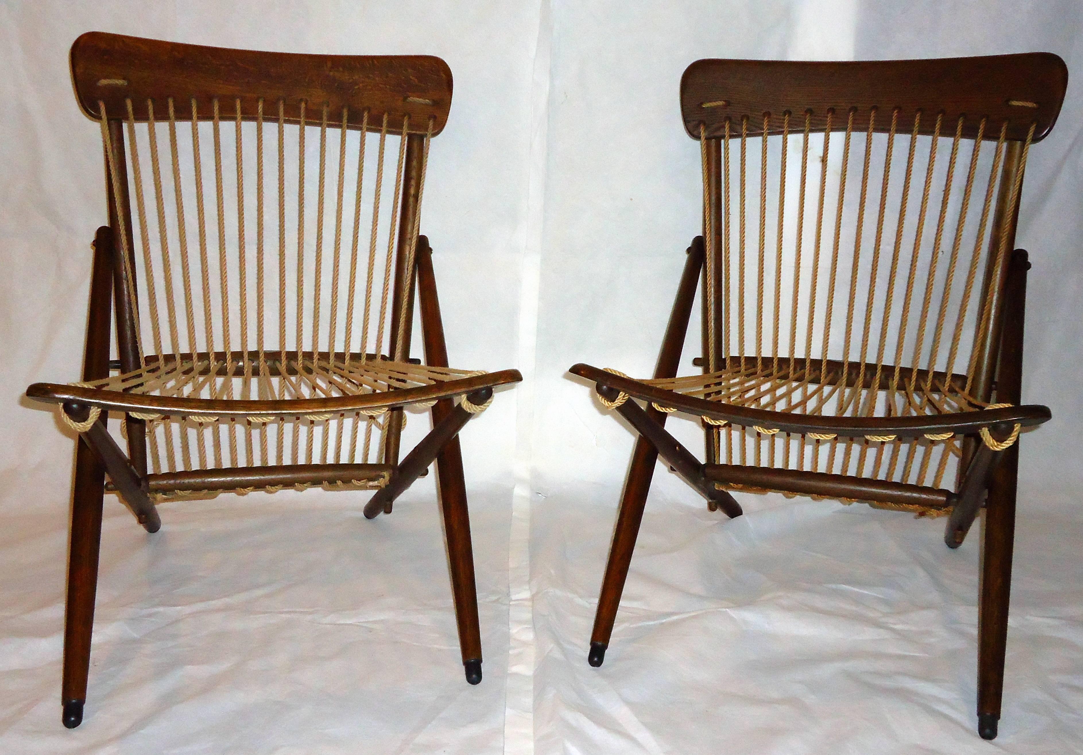 Extraordinarily rare pair of pre-1950 hand-carved oak and rope lounge chairs from the Maruni studio of Hiroshima, Japan. 
The turned oak framed chairs have hand dipped rubber feet, the original rope and the pre-1950 smoked oak finish. 
The chairs