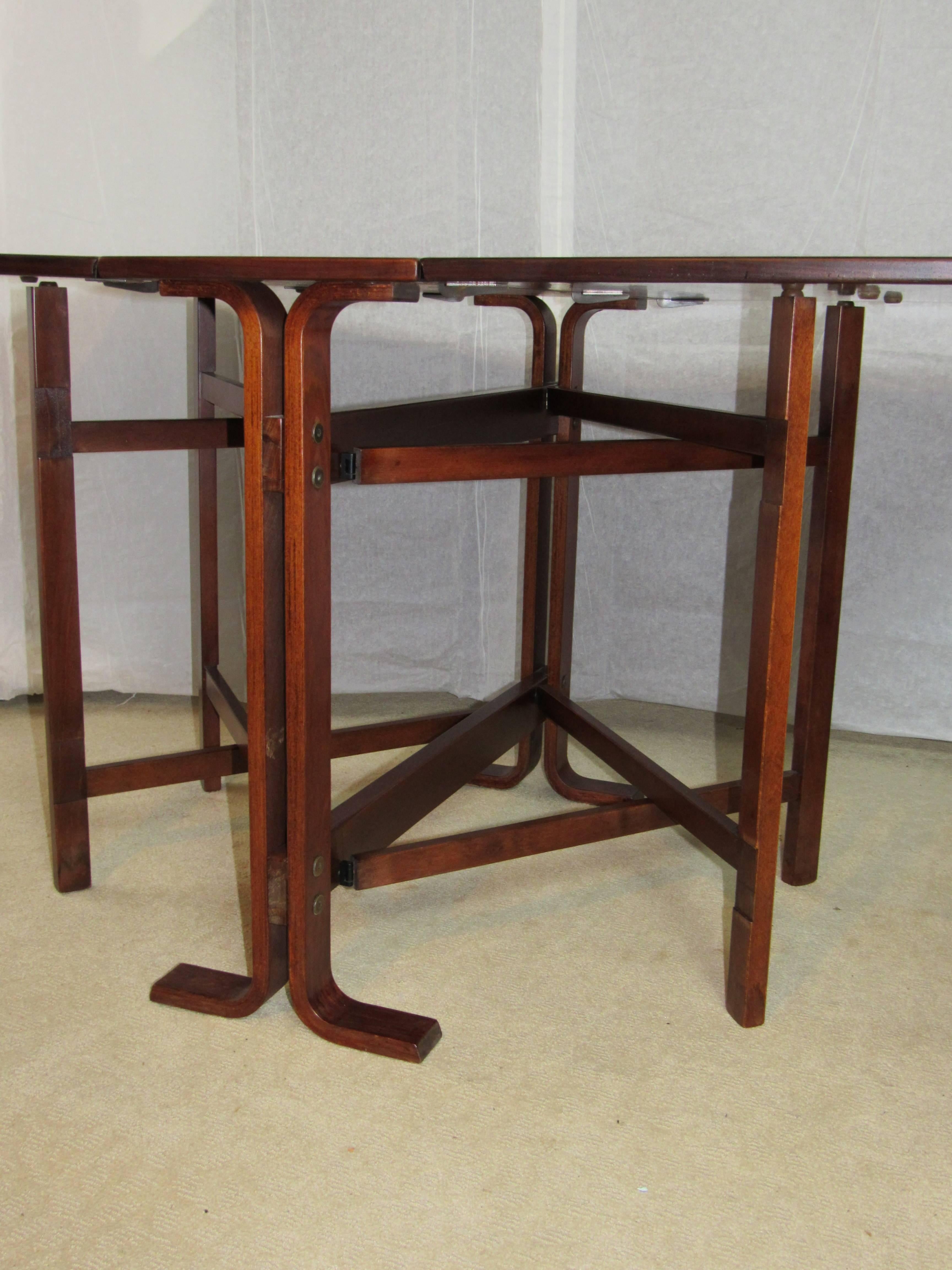 Classic dining table Model NR 4 designed by Bendt Winge for Kleppe Møbelfabrik of Norway in the mid-1950s. This is the rarer version with a rosewood top on a Teak base. Folds down to 13