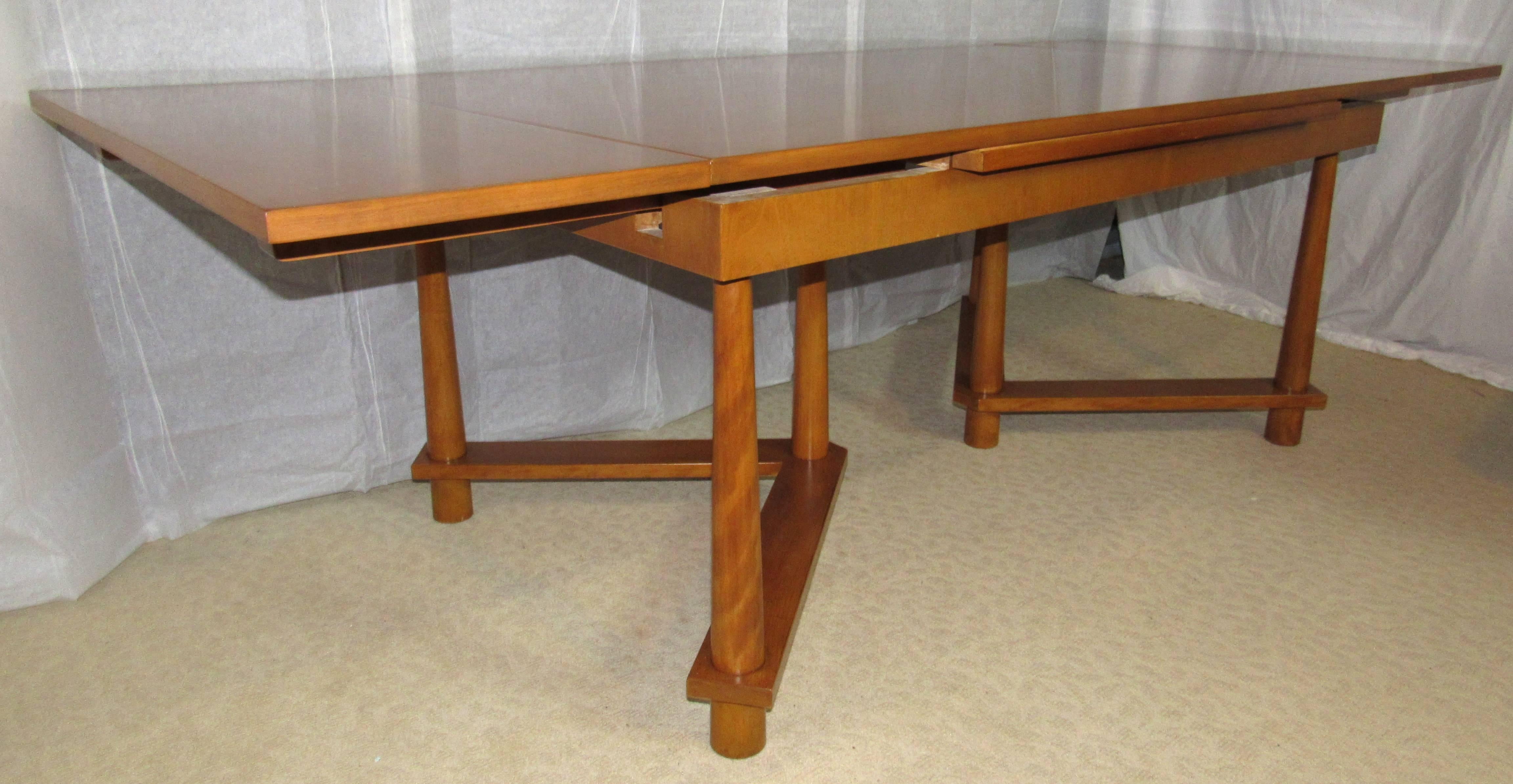 T. H. Robsjohn-Gibbings dining table with pullout end leaves on twin tripod bases with reverse tapered legs. 
One of Robsjohn-Gibbings scarcer designs this model 1626 walnut table was manufactured by Widdicomb in September of 1950. 
The table