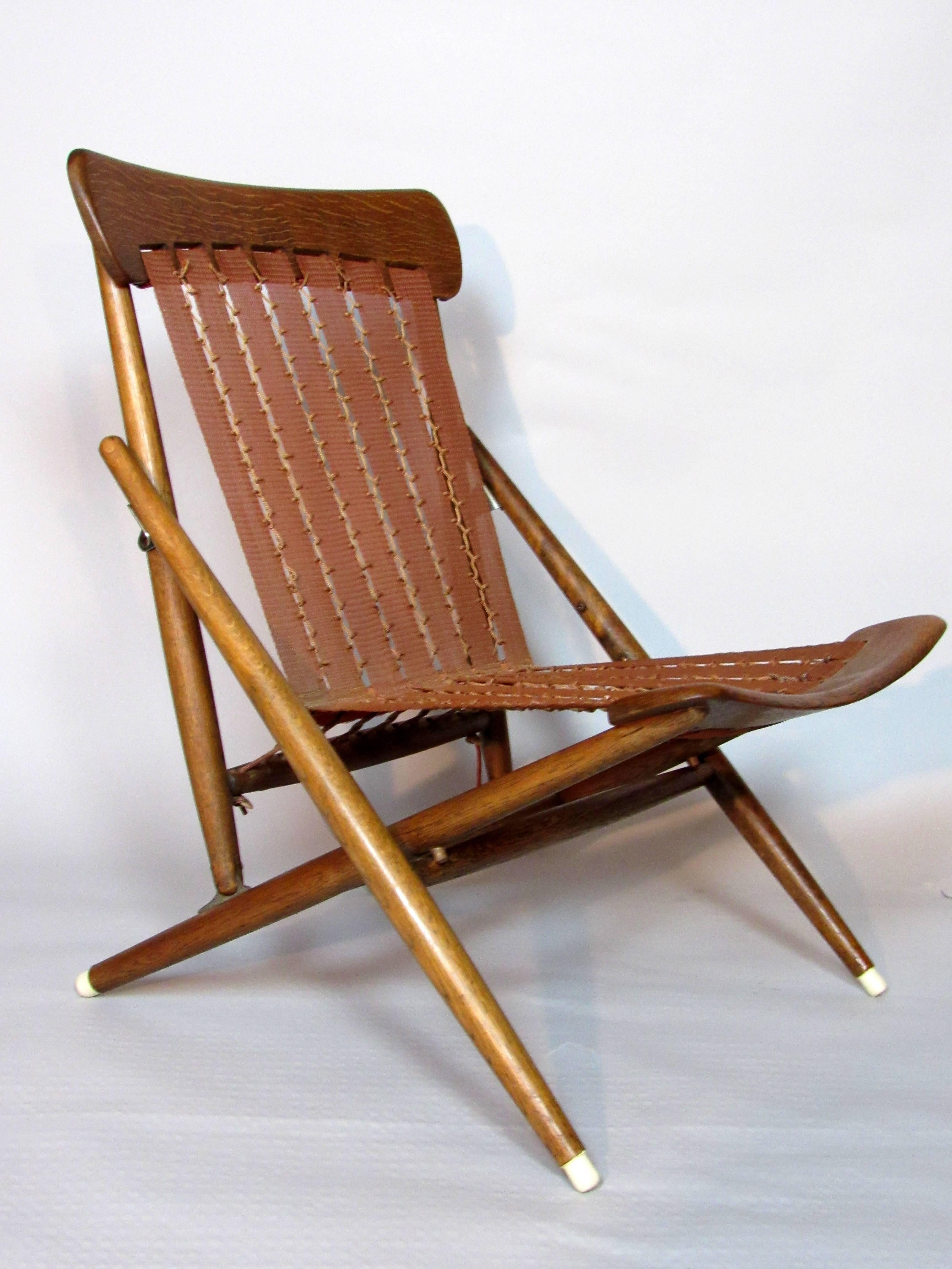 Pre-1950 hand turned oak folding lounge chair from the Maruni studio of Hiroshima, Japan.
The turned oak framed chair has hand dipped rubber feet and its original translucent nylon webbing that is hand bound with string in an intricate weaving. An