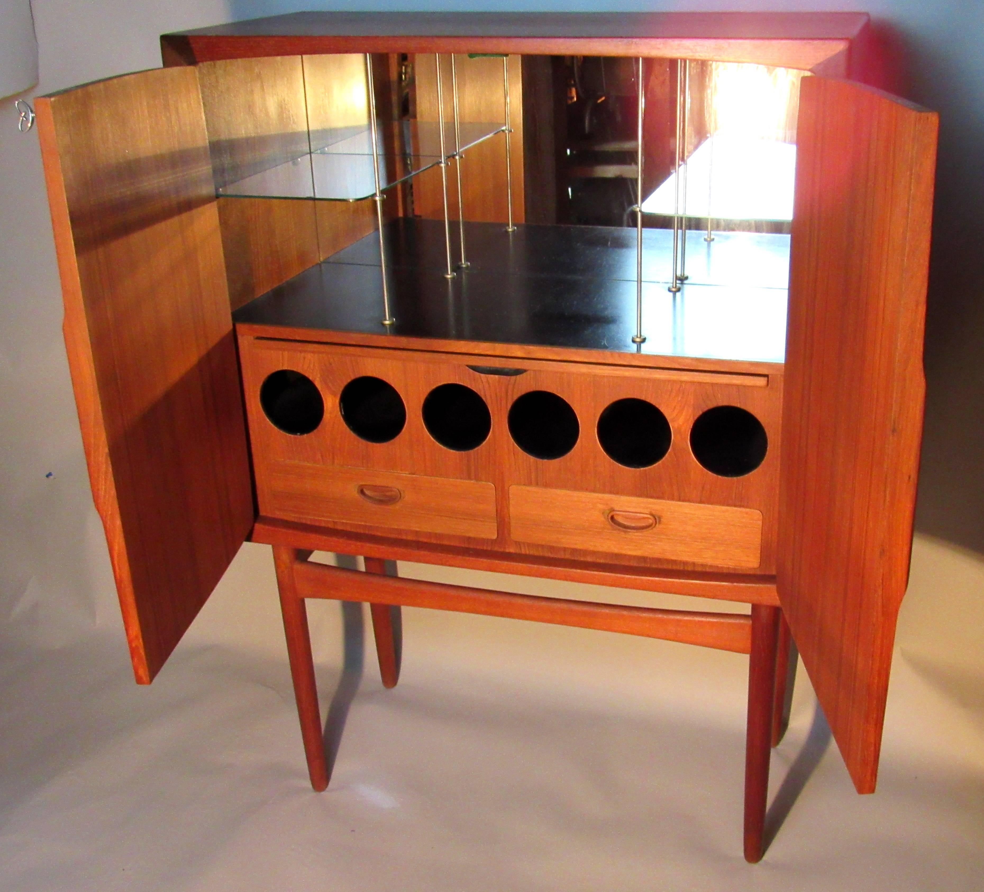 A teak dry bar by Torbjorn Afdal for Mellemstrands Møbelfabrik, Norway model Bacchus from the early 1950s.
The glass shelves have minor chips otherwise the bar is in excellent condition.
                 