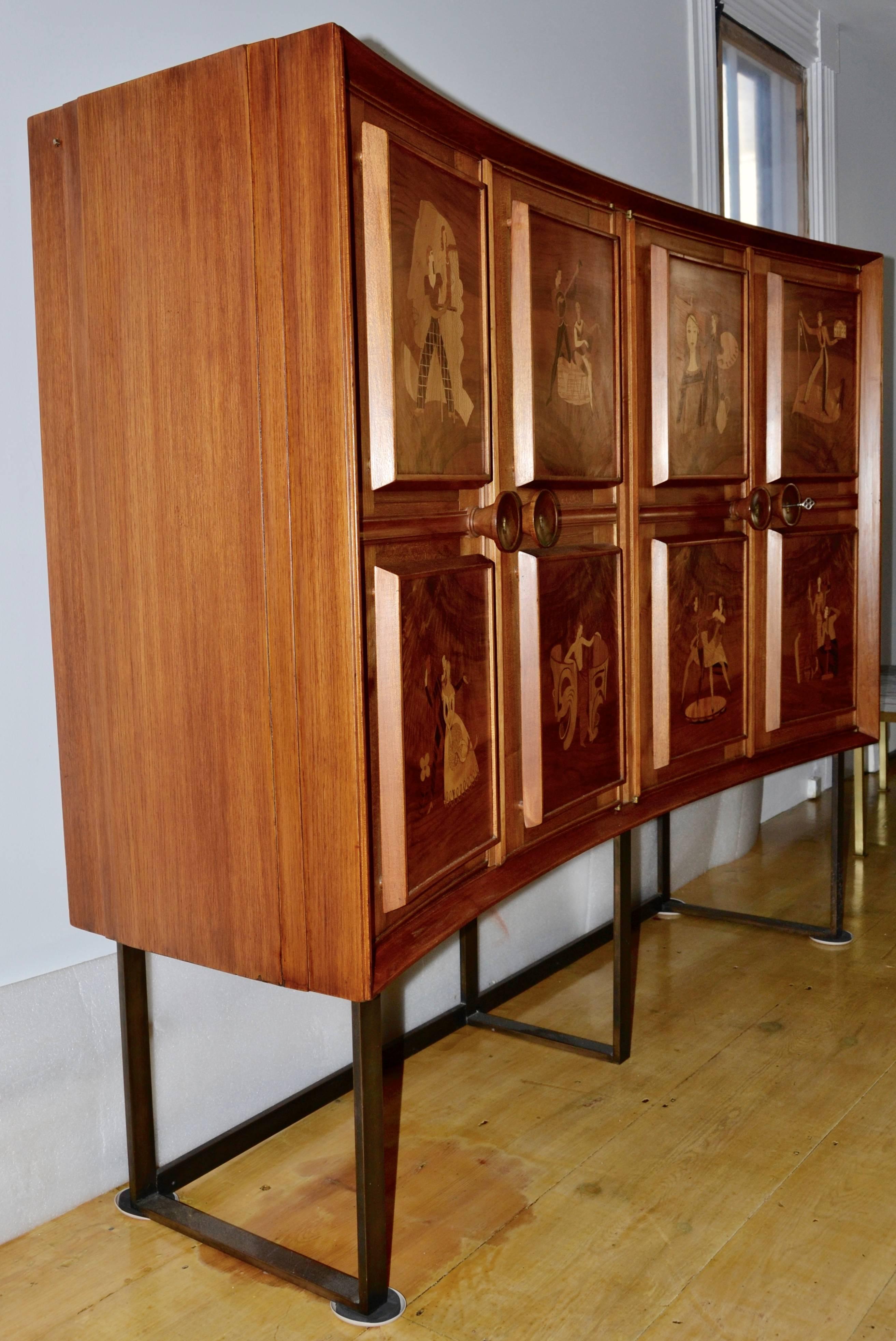 Eugenio Diez illuminated liquor cabinet from the early 1950s. 
The walnut demilune dry bar has finned sides, four locking doors mounted with eight backlit raised panels depicting the eight classical arts. 
The arts that Eugenio Diez chose to