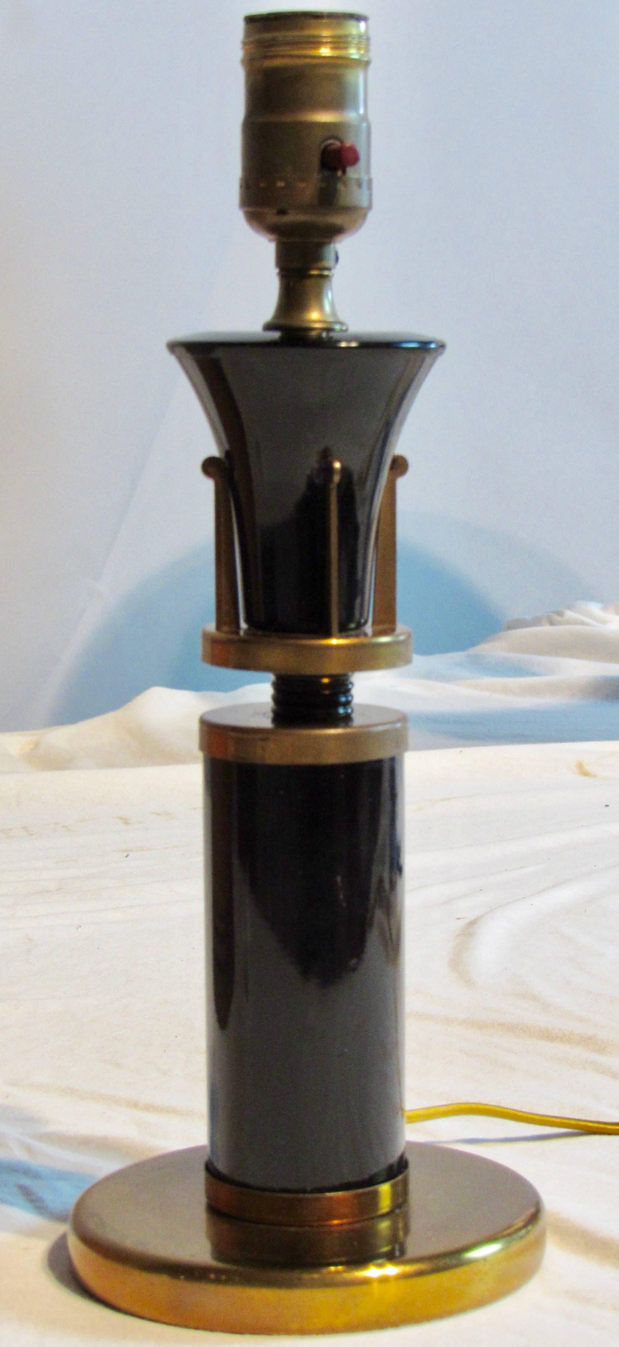 American Art Deco table lamp with gold washed metal and plasticine or another bakelite like coated body. 
The original printed paper shade is in excellent condition. 
The shade has a threaded harp support that screws onto the socket. There is an