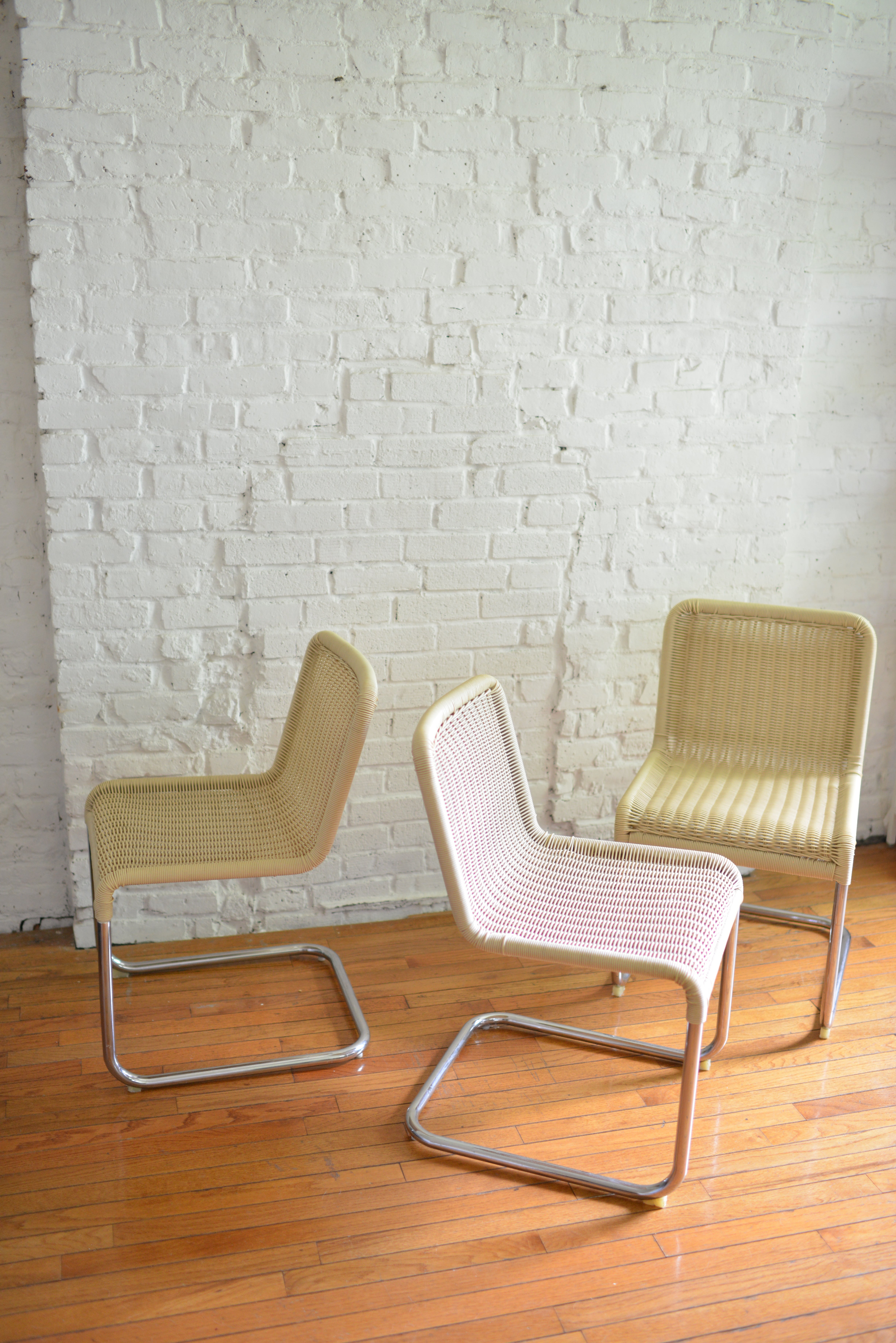 Set of 6 beautiful synthetic rattan and chrome cantilevered chairs in the style of Marcel Breuer. Acrylic cream rattan and tubular chrome bases make up these beautiful and durable chairs. All in original condition with some visible signs of wear but