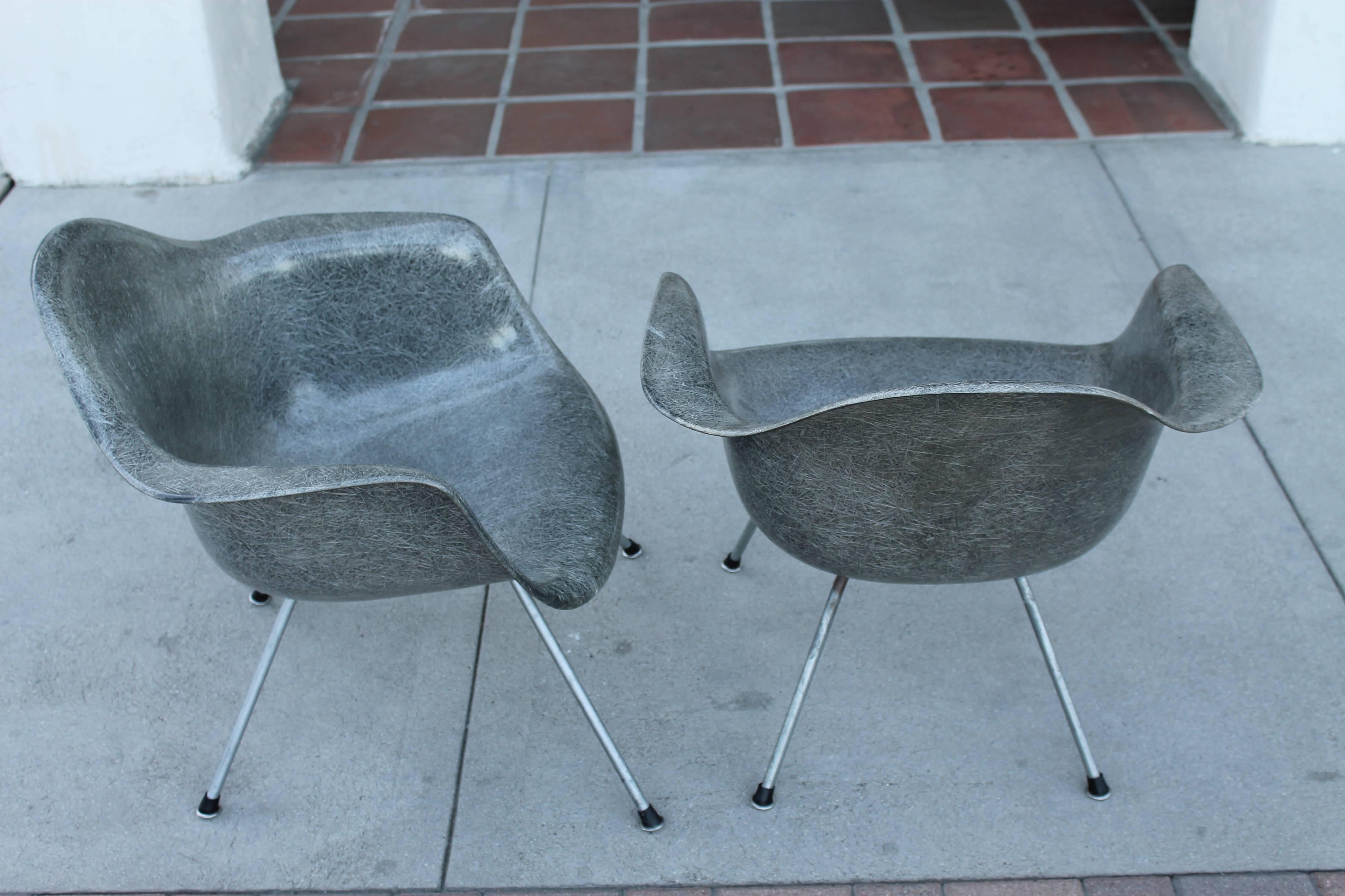 Pair of Ray and Charles Eames fiberglass bucket chairs. These are the early ones with the rope edging in elephant hide grey color.  Considered the first year of production.  One of the chairs has the early Zenith label. I rarely see these examples