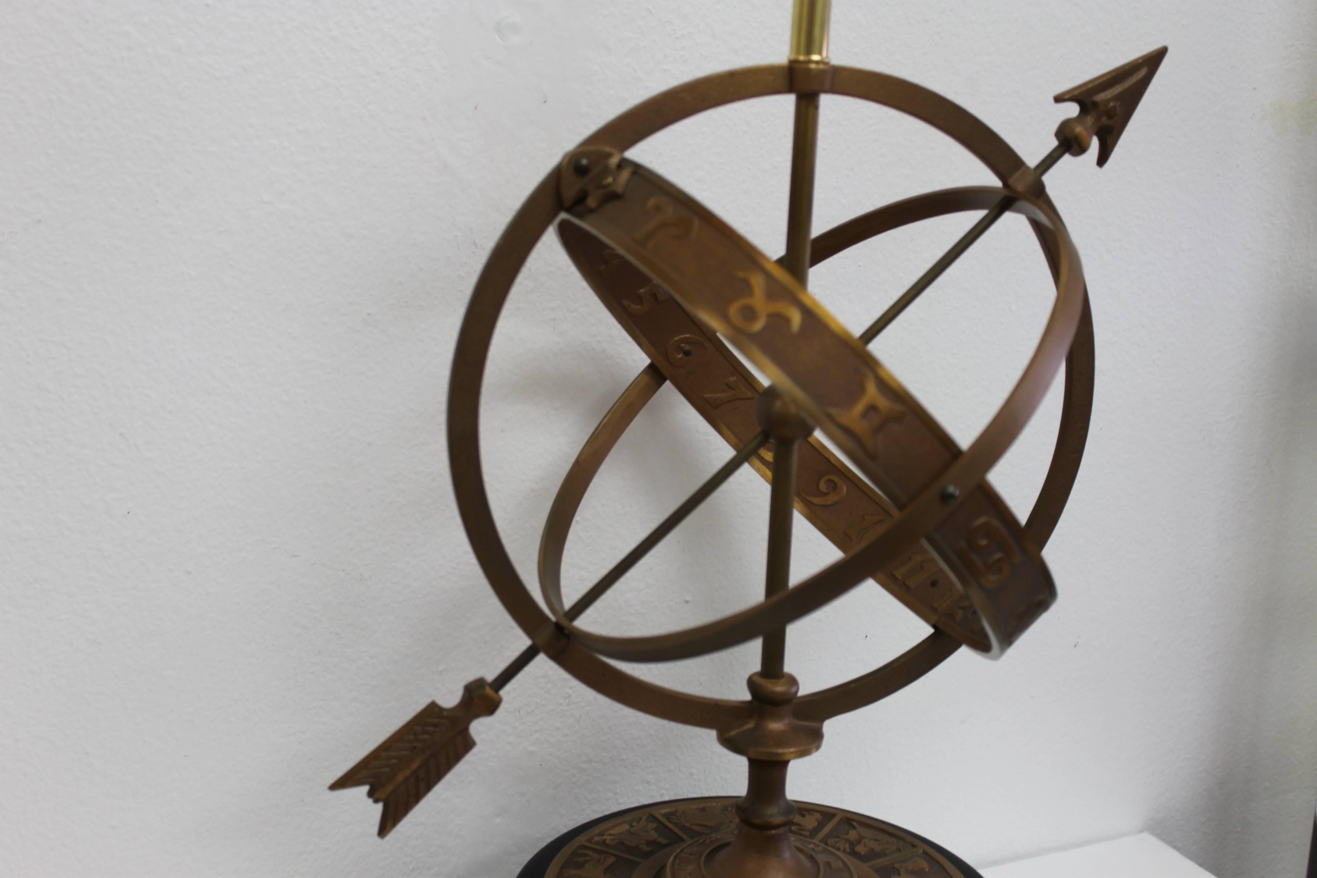 A bronze sundial table lamp in the form of zodiac signs with stylistic piercing arrow by Frederick Cooper, Chicago. Base is 10.25