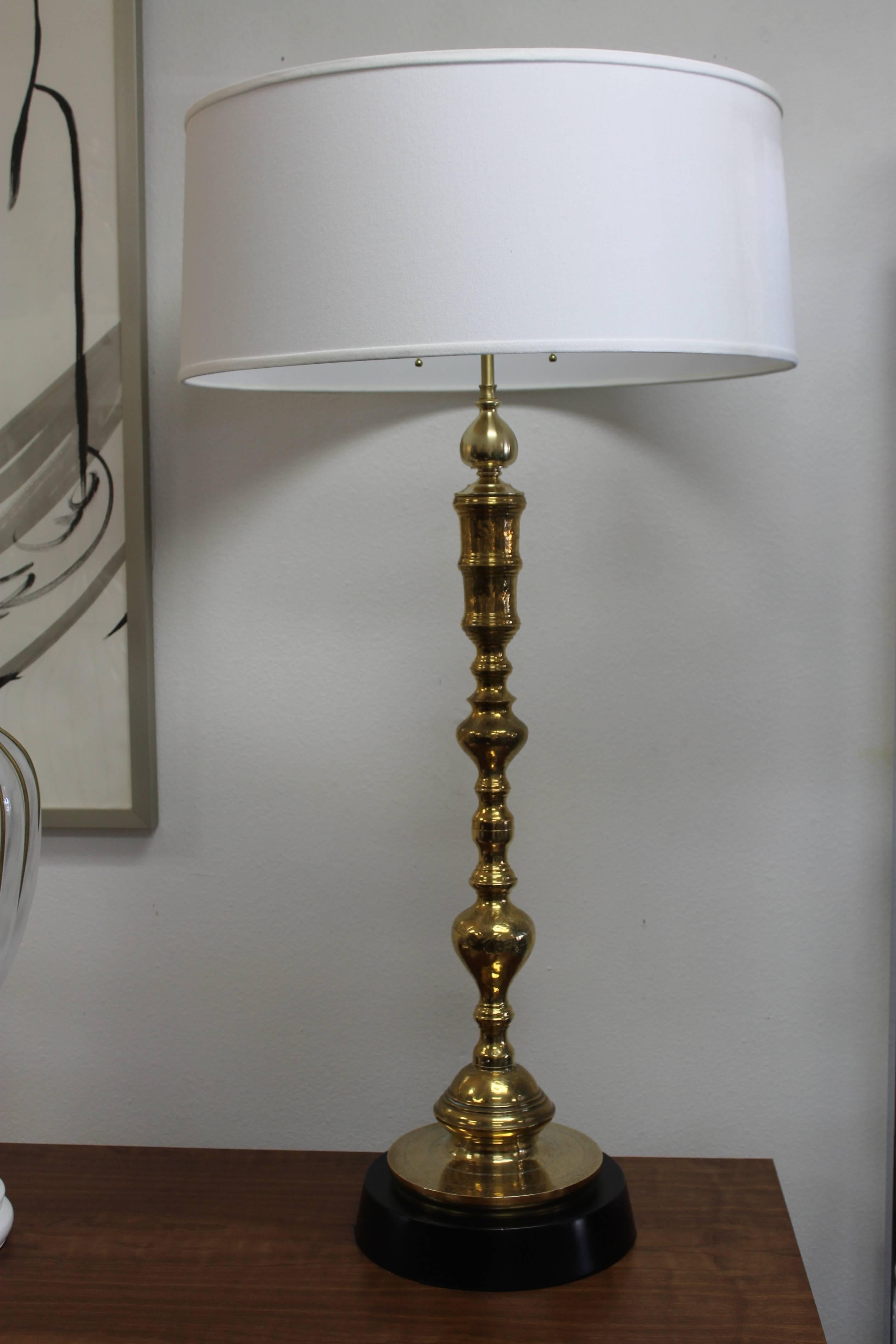 Monumental pair of custom designed Moroccan lamps. We took a pair of brass candlesticks and modified them to produce an elegant pair of brass lamps. Base has a switch so that you can either turn on/off the lamps. Base is 11