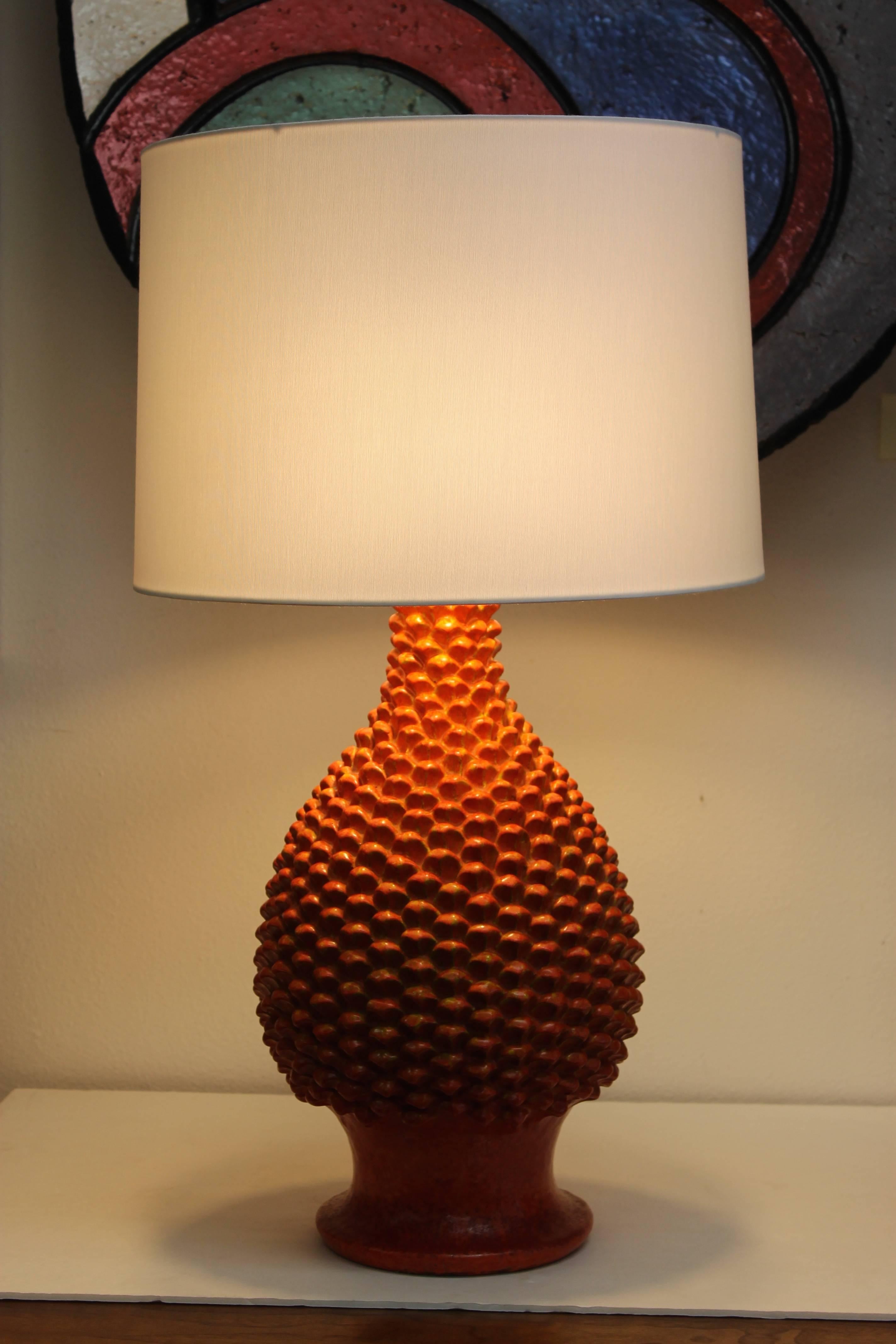 Ceramic orange drip glaze lamp designed by Marcello Fantoni (1915-2011). Signed on base. Ceramic portion is 17" high and 10" diameter. Base is 7.25" diameter. Total height from base to the bottom of socket is 26".  Lamp shade not