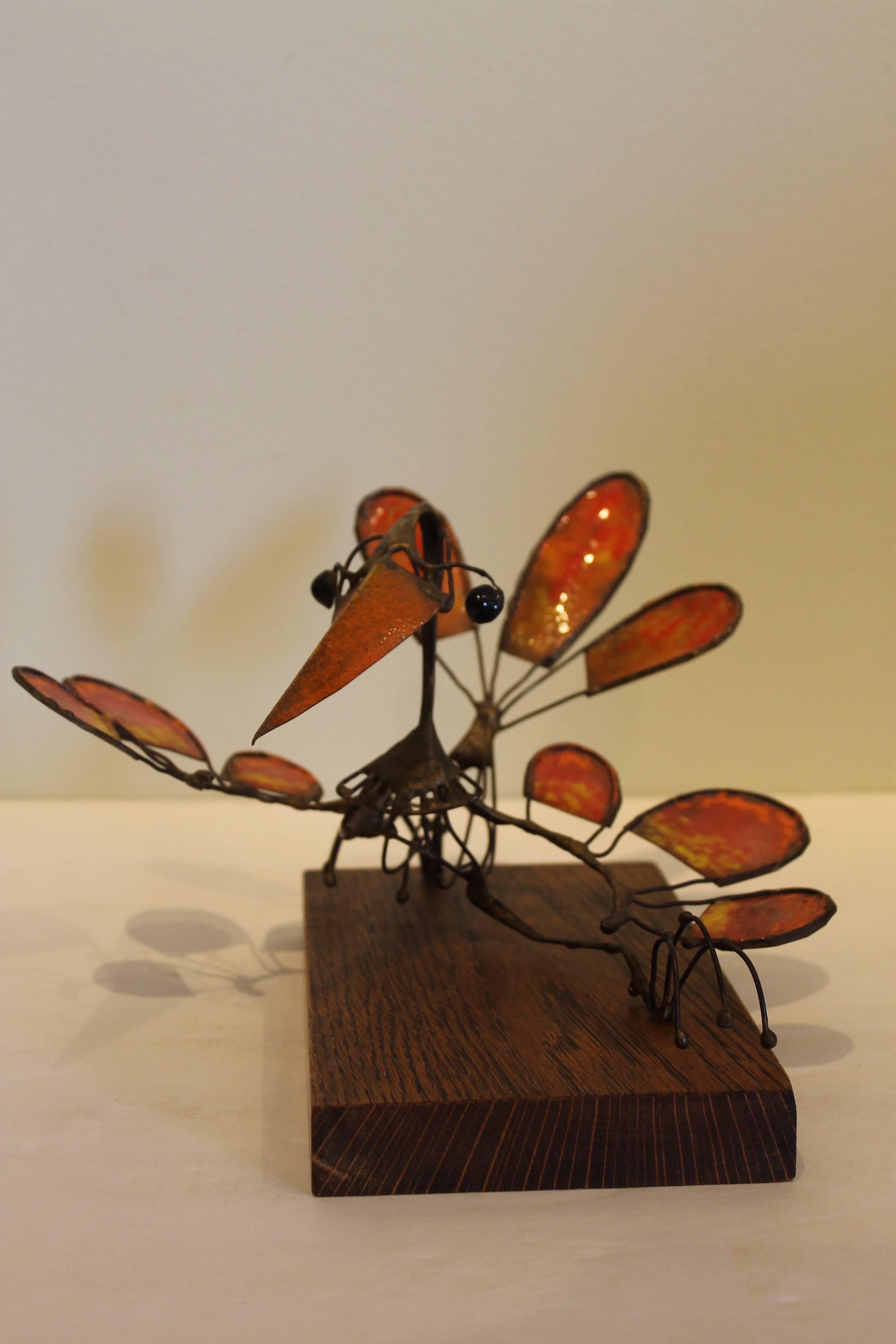 A whimsical wire and enamel sculpture of a bird creature by California sculptor Russ Shears.  Braised wire construction with red-yellow-orange enameled feathers, orange beak and black enameled eyes.  Included with this sculpture is a 1966 issue of