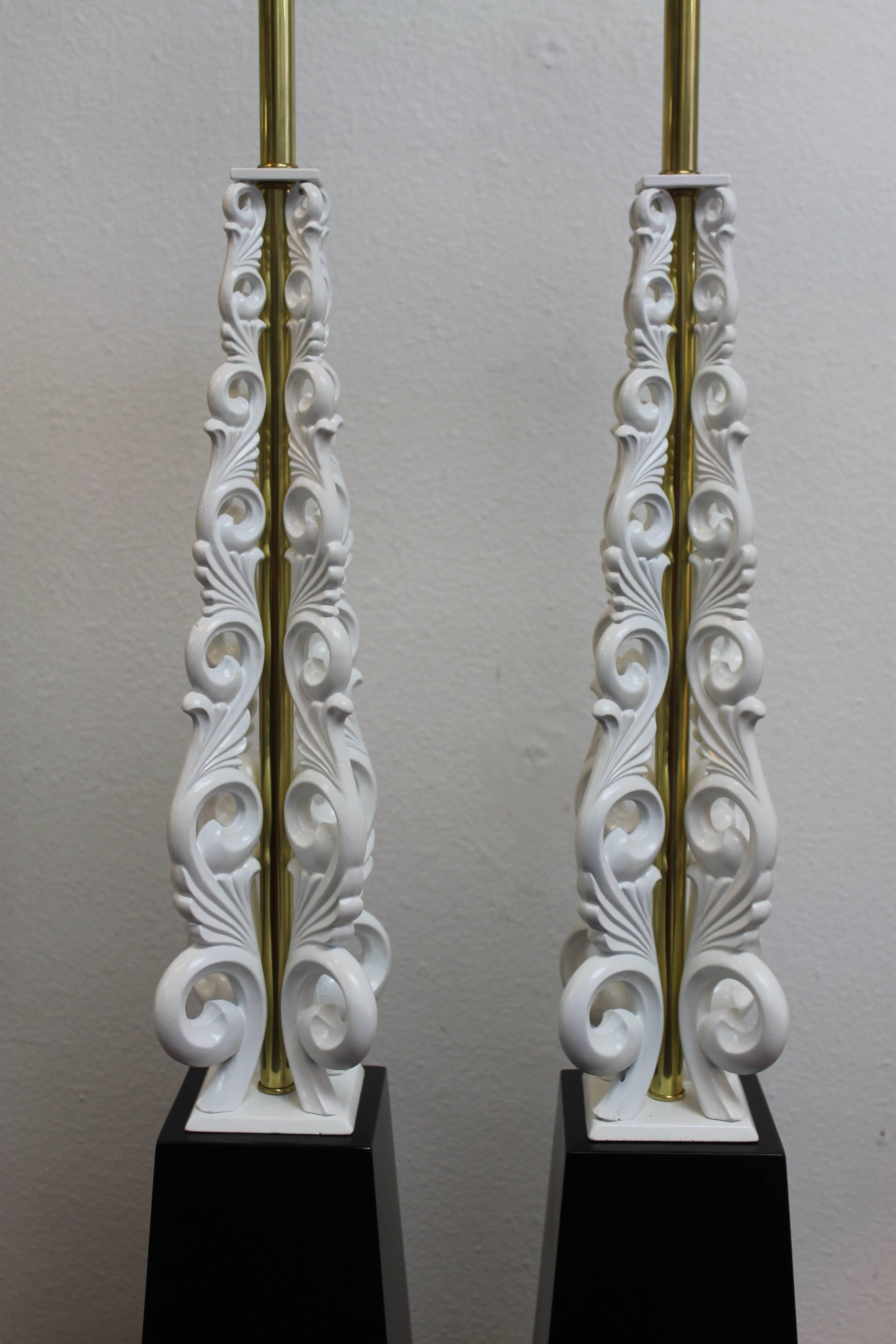 Elegant pair of lamps each with four white aluminum sculpted uprights on top of a wood base. The uprights were originally brass and we decided to update them in white. They have been professionally rewired. They each contain an on/off switch on