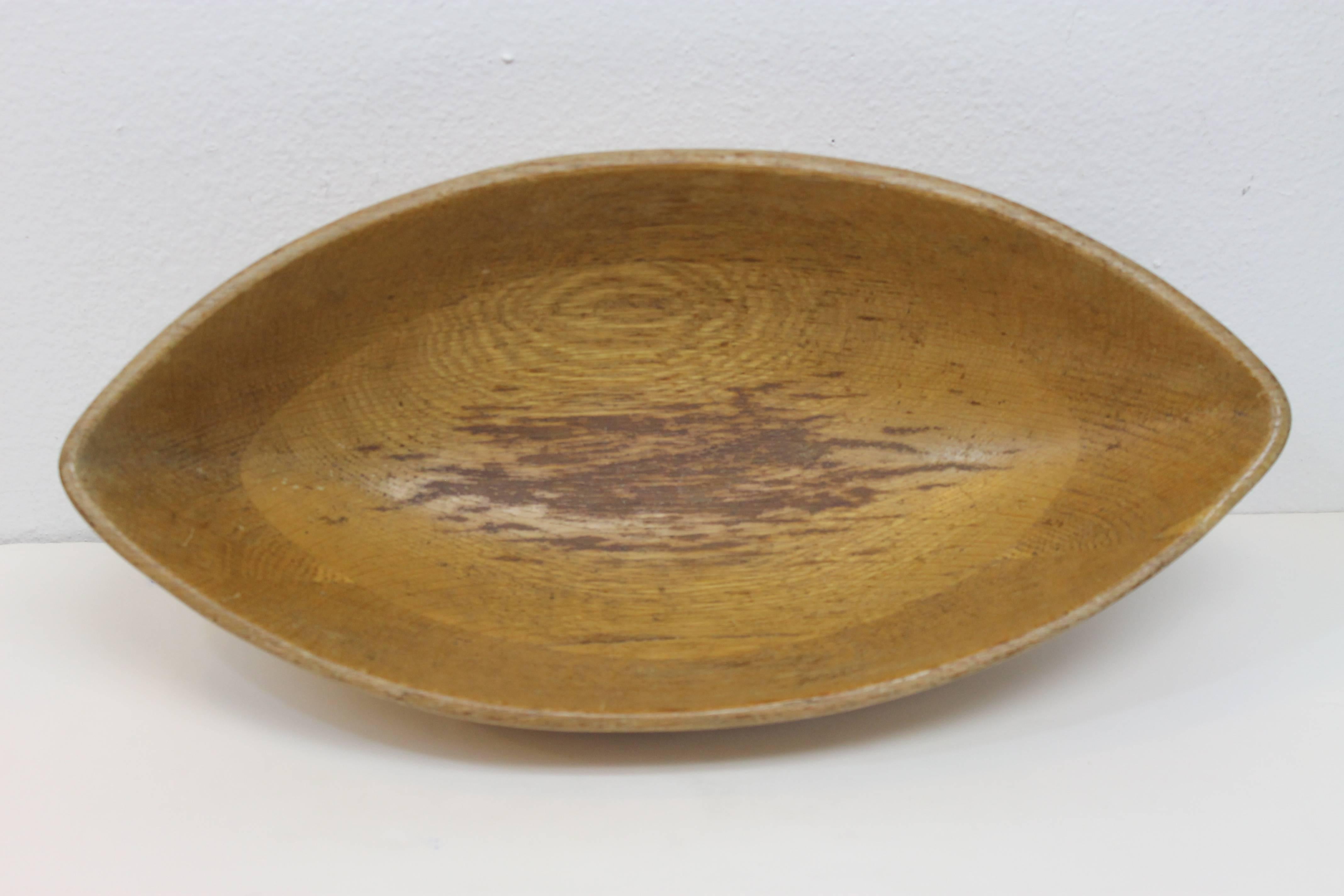 Serving bowl shaped like a football designed by Mary Wright. Part of a wood line designed by husband and wife Industrial designers Russel Wright / Mary Wright. Measures 15.75
