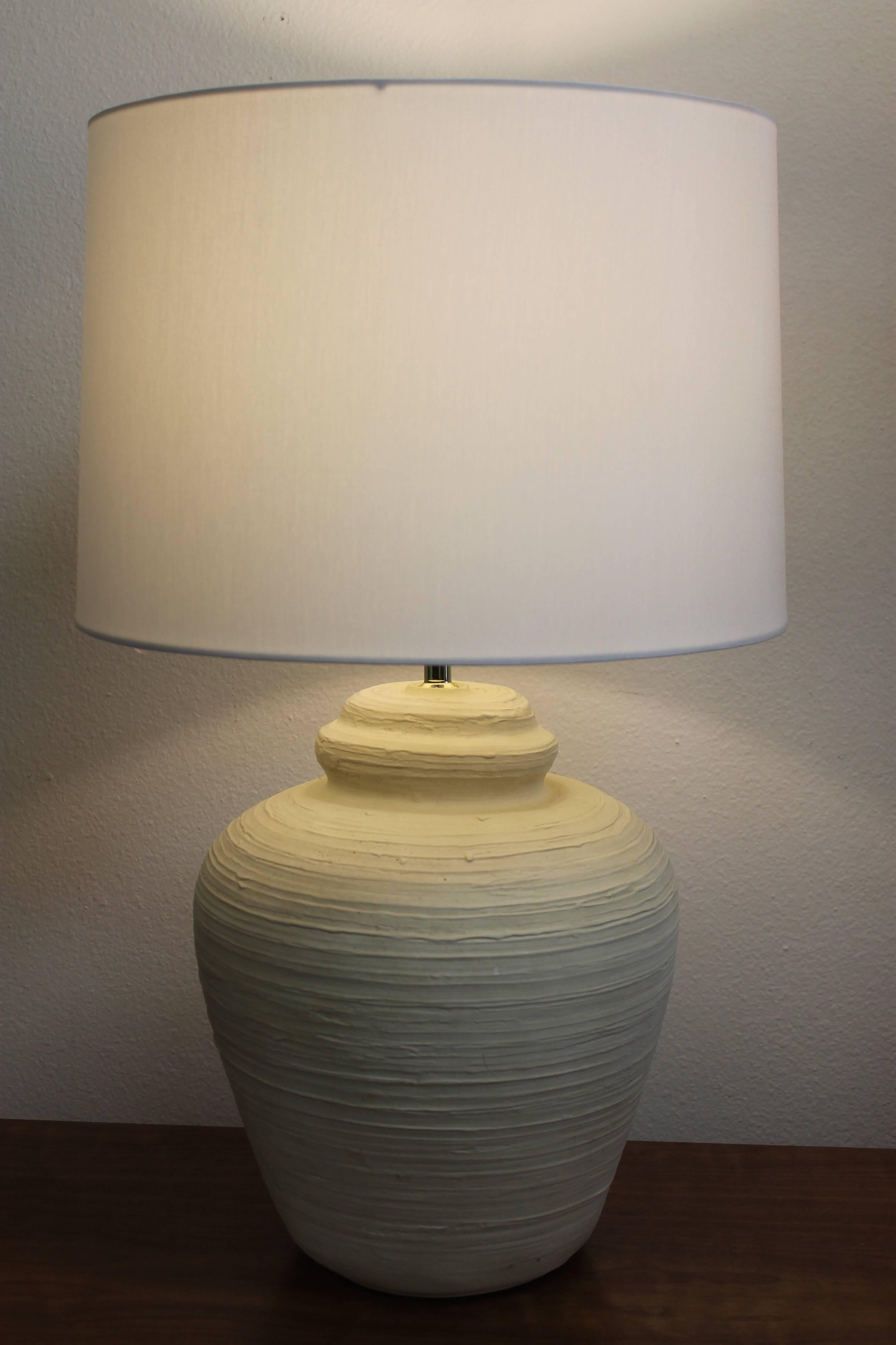 Pair of off-white ceramic table lamps with a swirl pattern. They are dated 1975. The ceramic portion is 13.5" high, 16" from base to the bottom of socket. Middle section is 11.75" diameter. Lamps have been professionally rewired. 