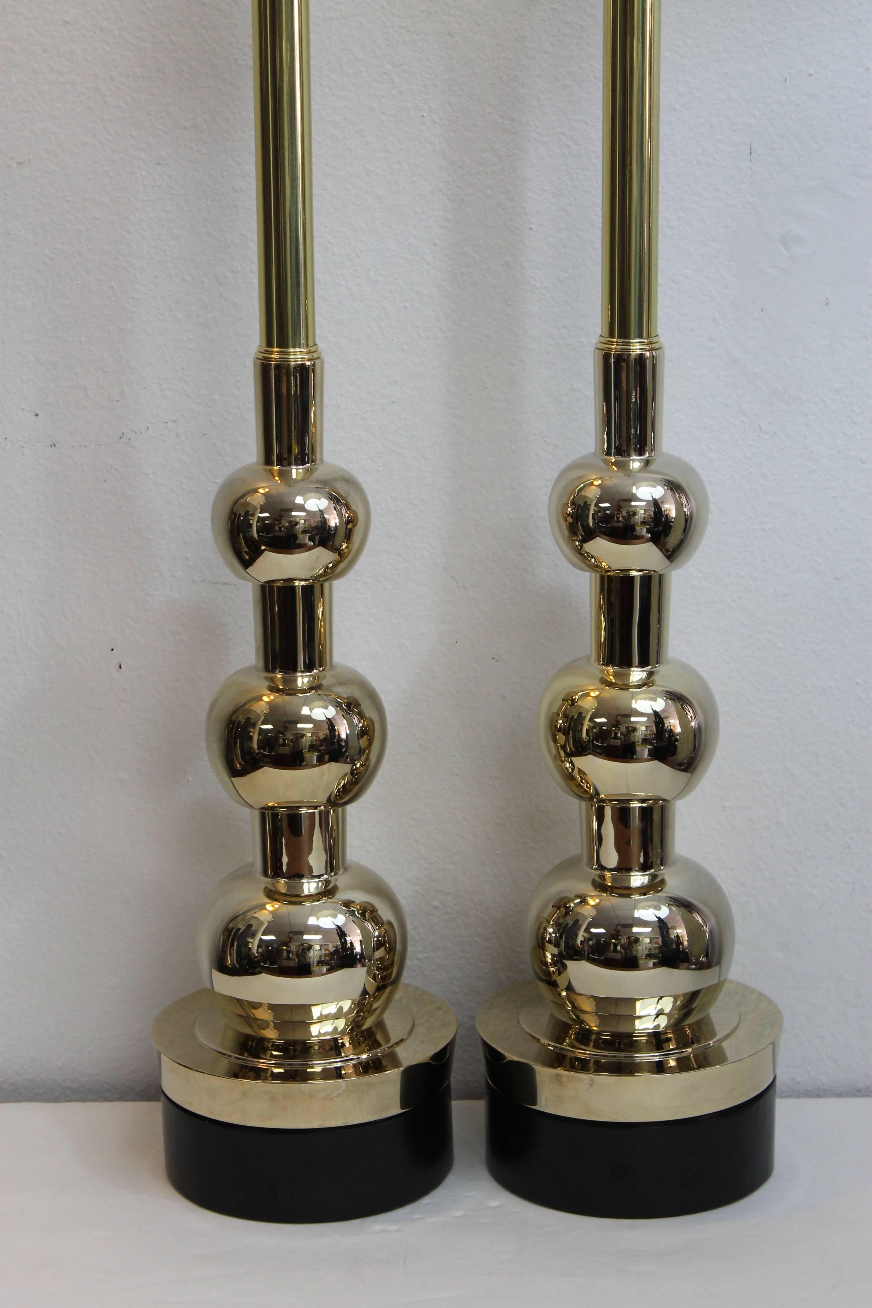 Sculptural pair of Stiffel table lamps in a bronze, brass finish. Lamps were originally a dull chrome and we decided to updated them. The neck is original brass which was polished. The remainder was re-brassed/bronzed. Wood base has been repainted
