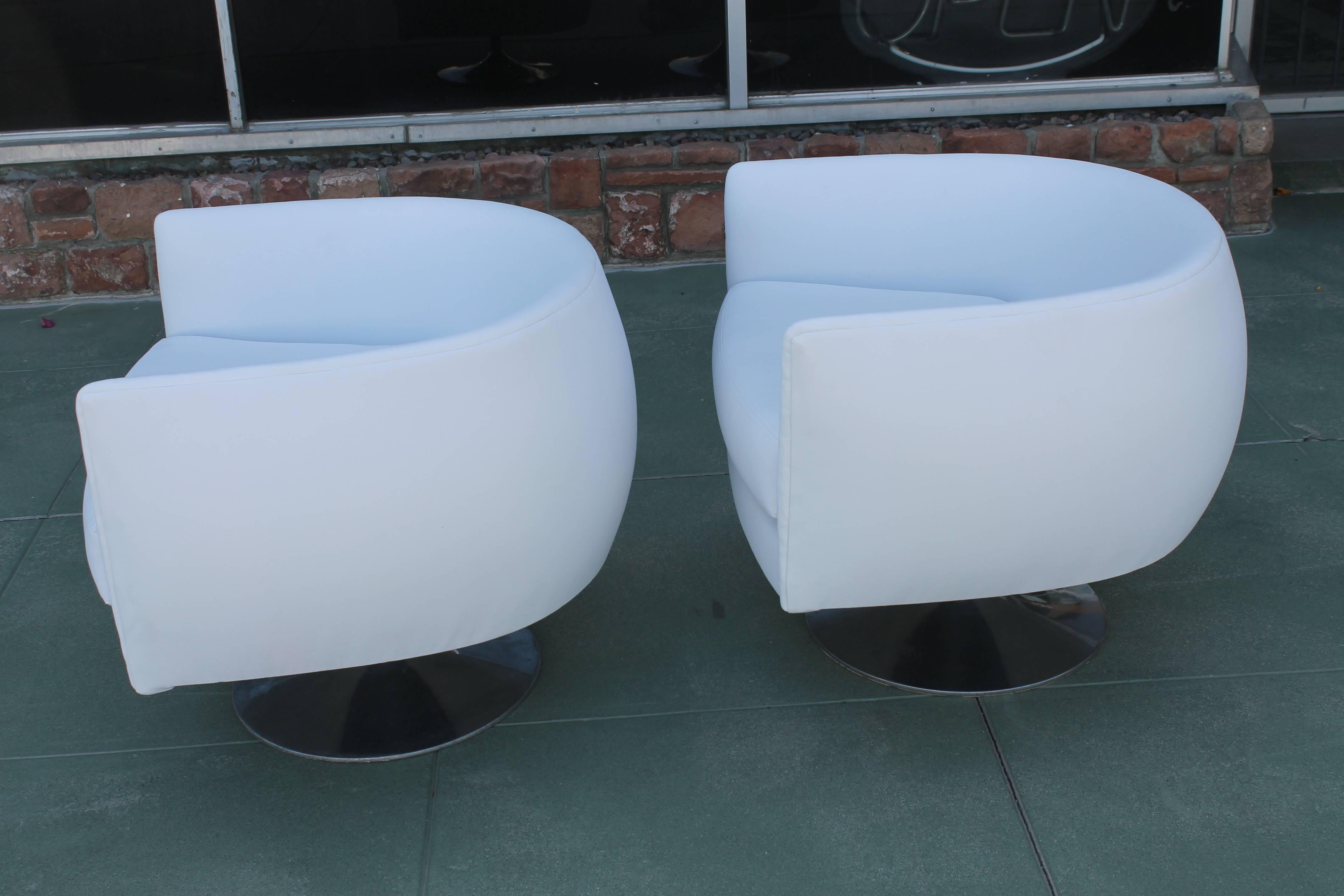 Pair of newly upholstered swivel lounge chairs. In the style of Milo Baughman. 
 Aluminum base has been polished and shows an incredible patina. Measures: Base is 18” diameter, 9” high. Bucket is 30” wide, 30” deep, seat is 24” from front to back of