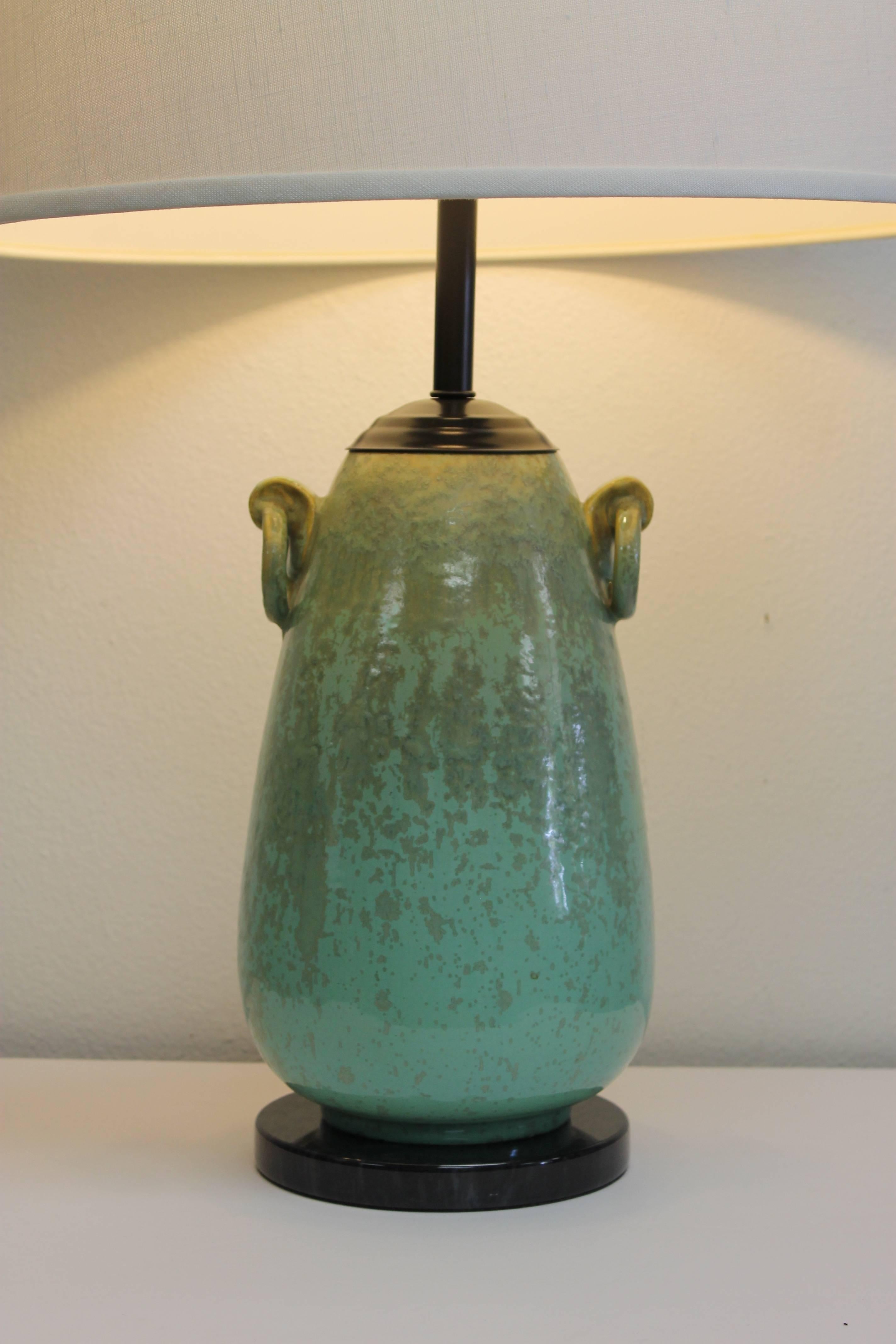 Sculptural table lamp by Fulper pottery consisting of two ring handles. Lamp has been updated by adding a marble base and black hardware. Beautiful green run glaze throughout. Base is 7" diameter. Vase is 13" high and 8" diameter.
