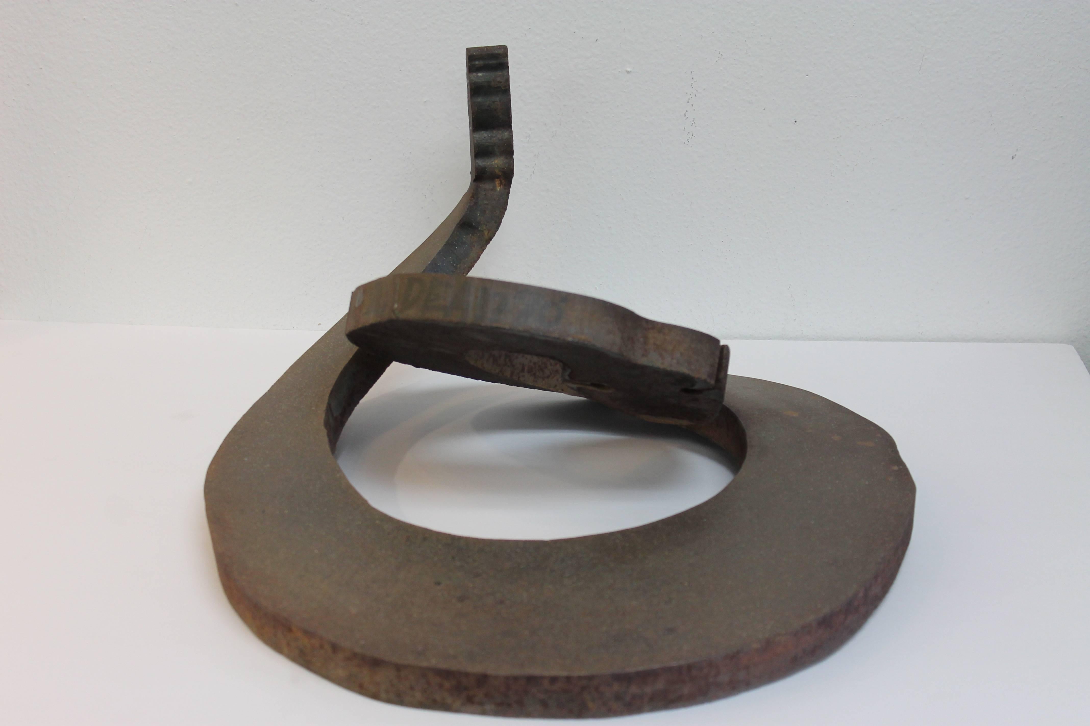 A cut steel form of a coiled rattlesnake, circa 1970. Difficult to make out the full signature but it looks like a last name of DEAN 70'. Sculpture measures 18