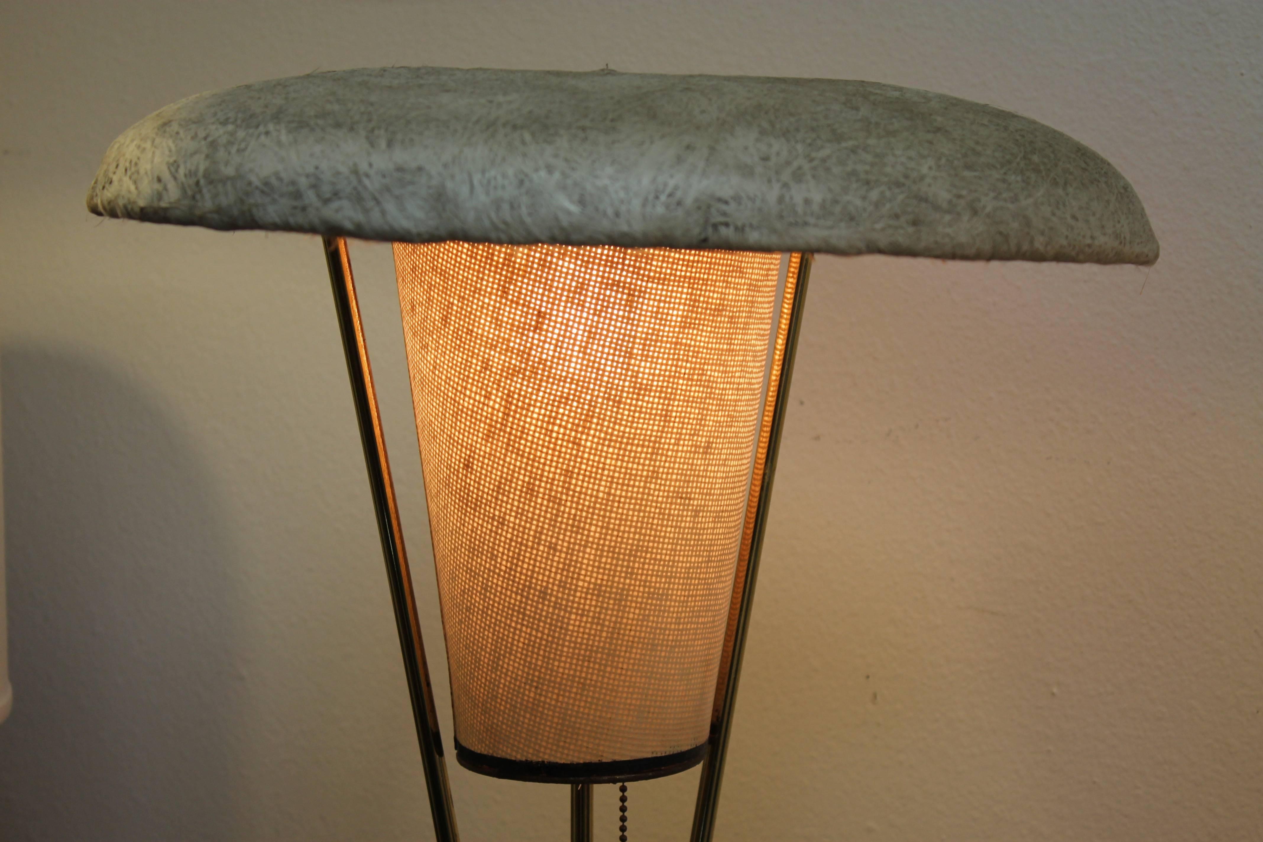 A circa 1950s table lamp with boomerang shaped wood base, brass hardware, woven linen cone shade and spun fiberglass deflector. The fiberglass top has a circular indentation that really sets off the design. Measure: Overall height of this lamp is