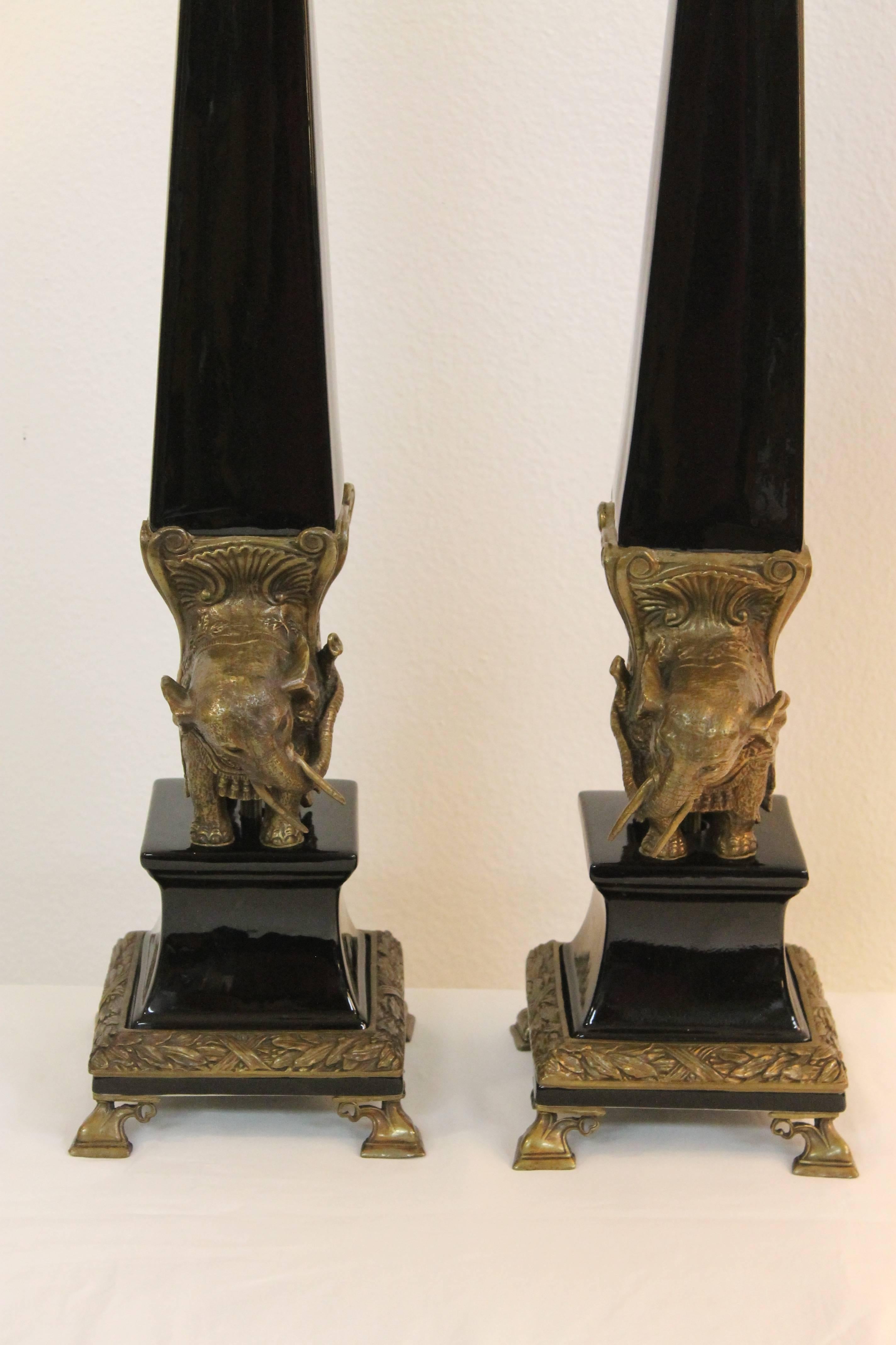 A matched pair of cast brass elephant lamps with black glazed porcelain obelisks. Elephants are modeled after the 1667 sculpture by Bernini in Rome. Very finely detailed castings and high quality construction on these lamps. These are newly rewired.