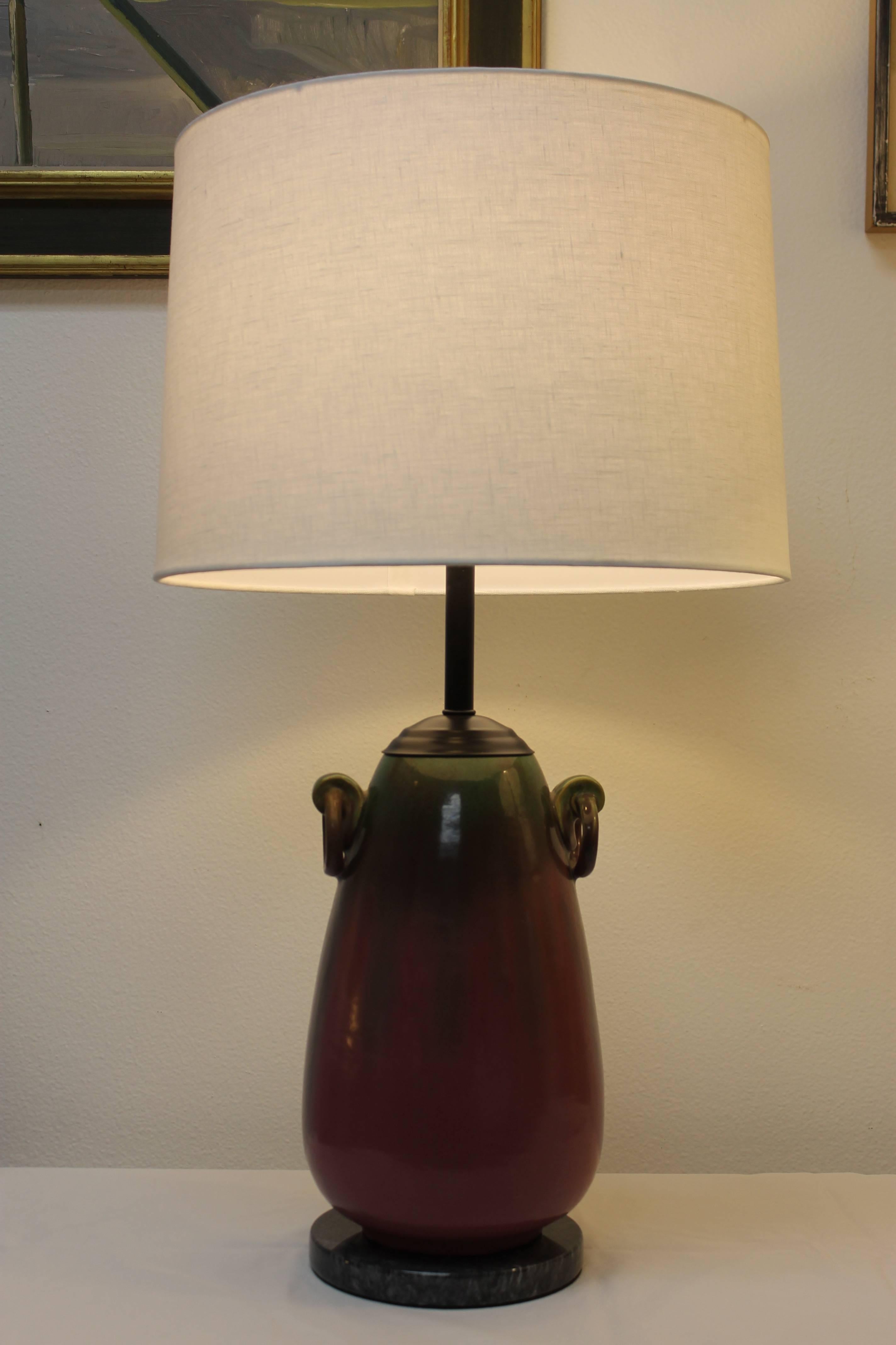 Sculptural table lamp by Fulper pottery consisting of two ring handles. Lamp has been updated by adding a marble base and black hardware. Beautiful purple and green run glaze throughout. Base is 7