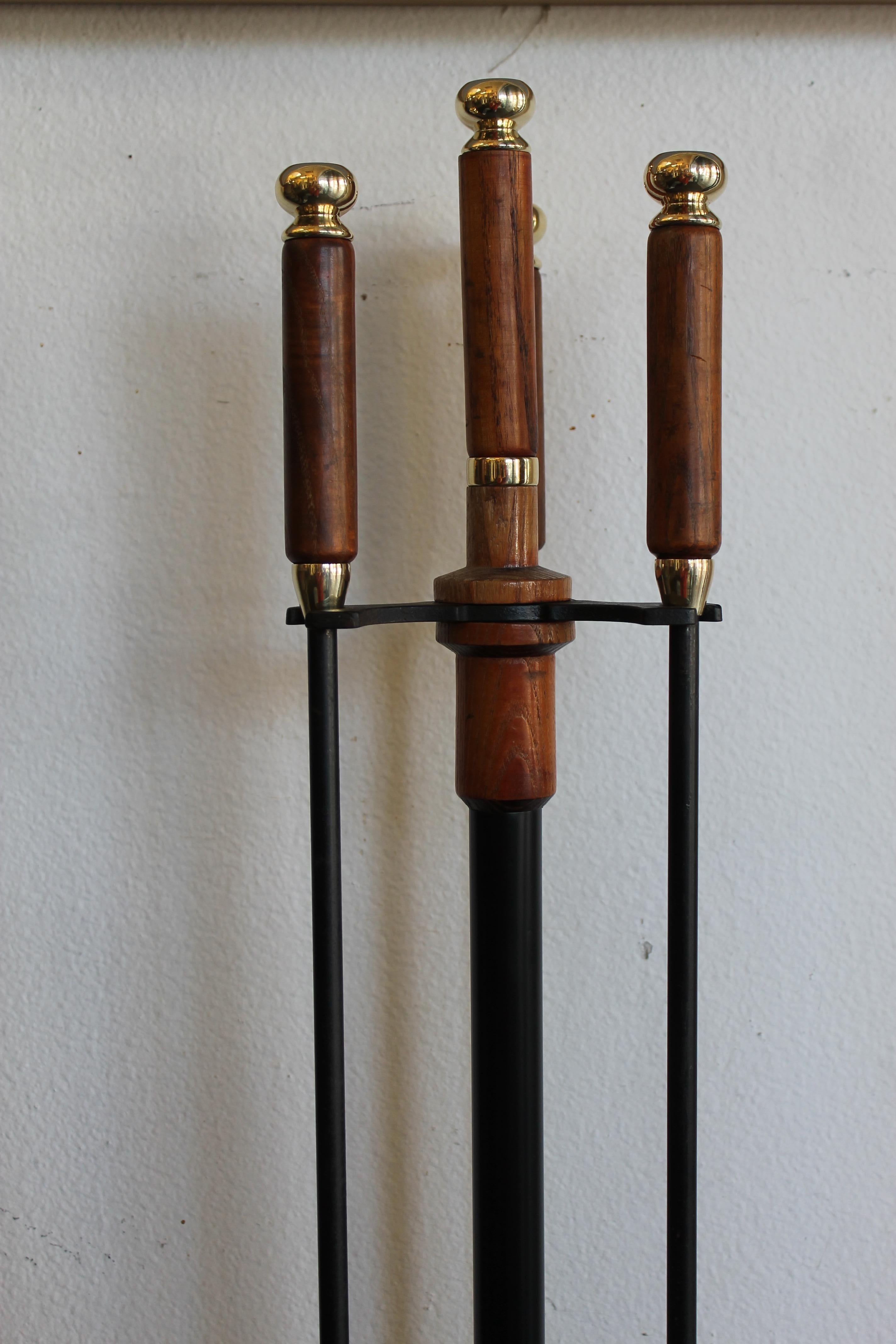 Elegant brass and wood midcentury fireplace fire tools. We polished the brass portions of the fireplace set. Total height with fire tools in place is 36.5”. Base is 11” wide x 8” deep. Tools are about 33” high.